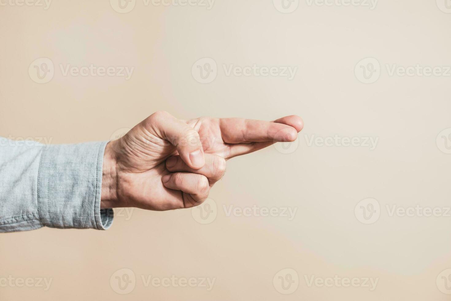 Close up image of  male hand with  crossing two finger gesture. photo