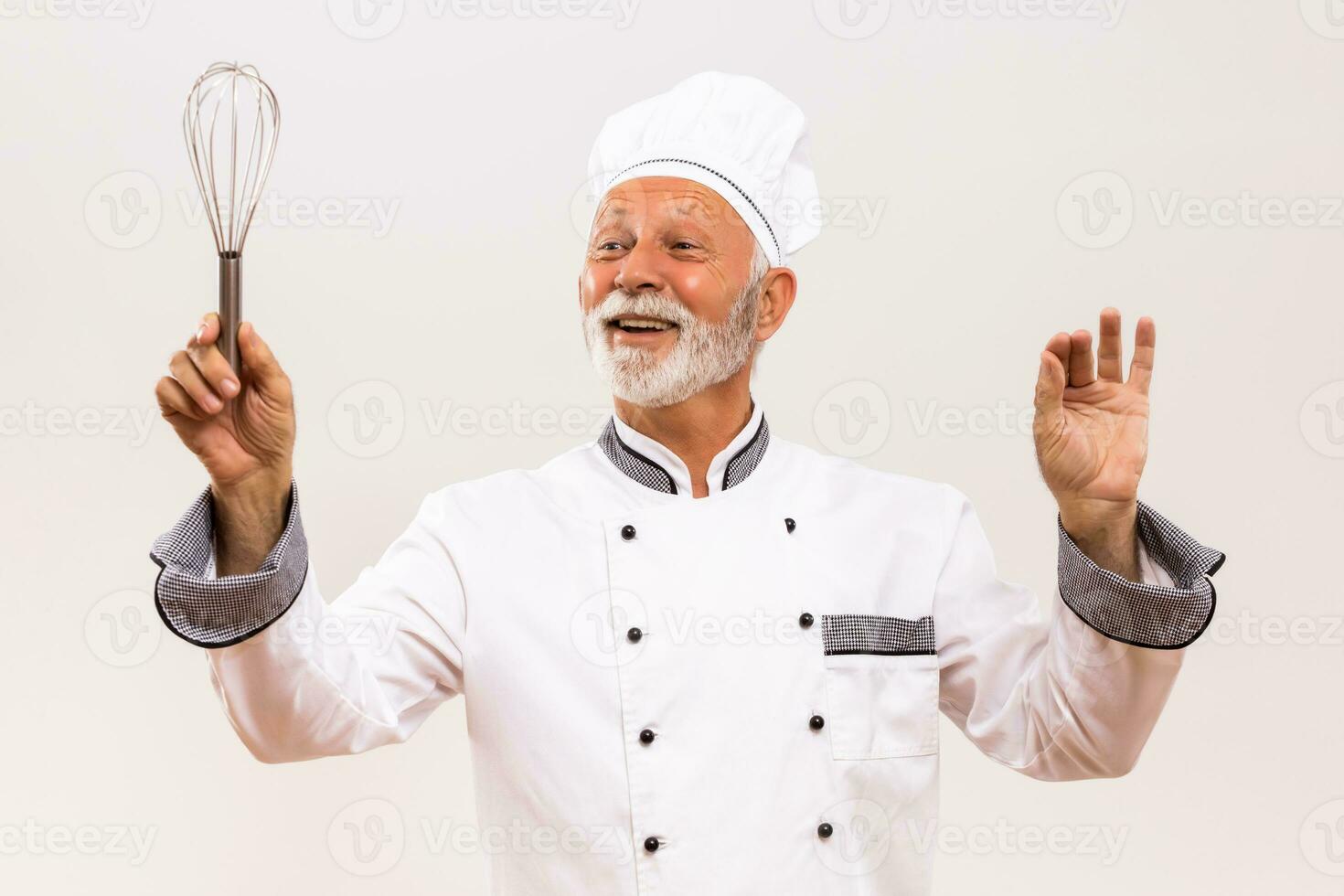 Image of  musical conductor senior chef with wire whisk on gray background. photo