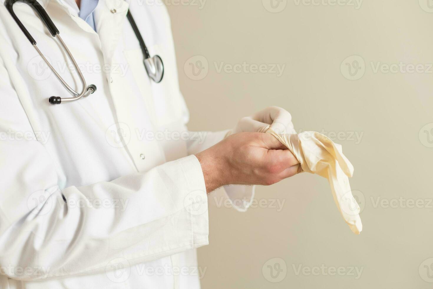 Image of male doctor putting on protective gloves. photo