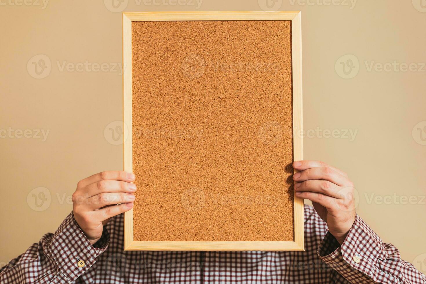 Image of man holding empty corkboard. photo