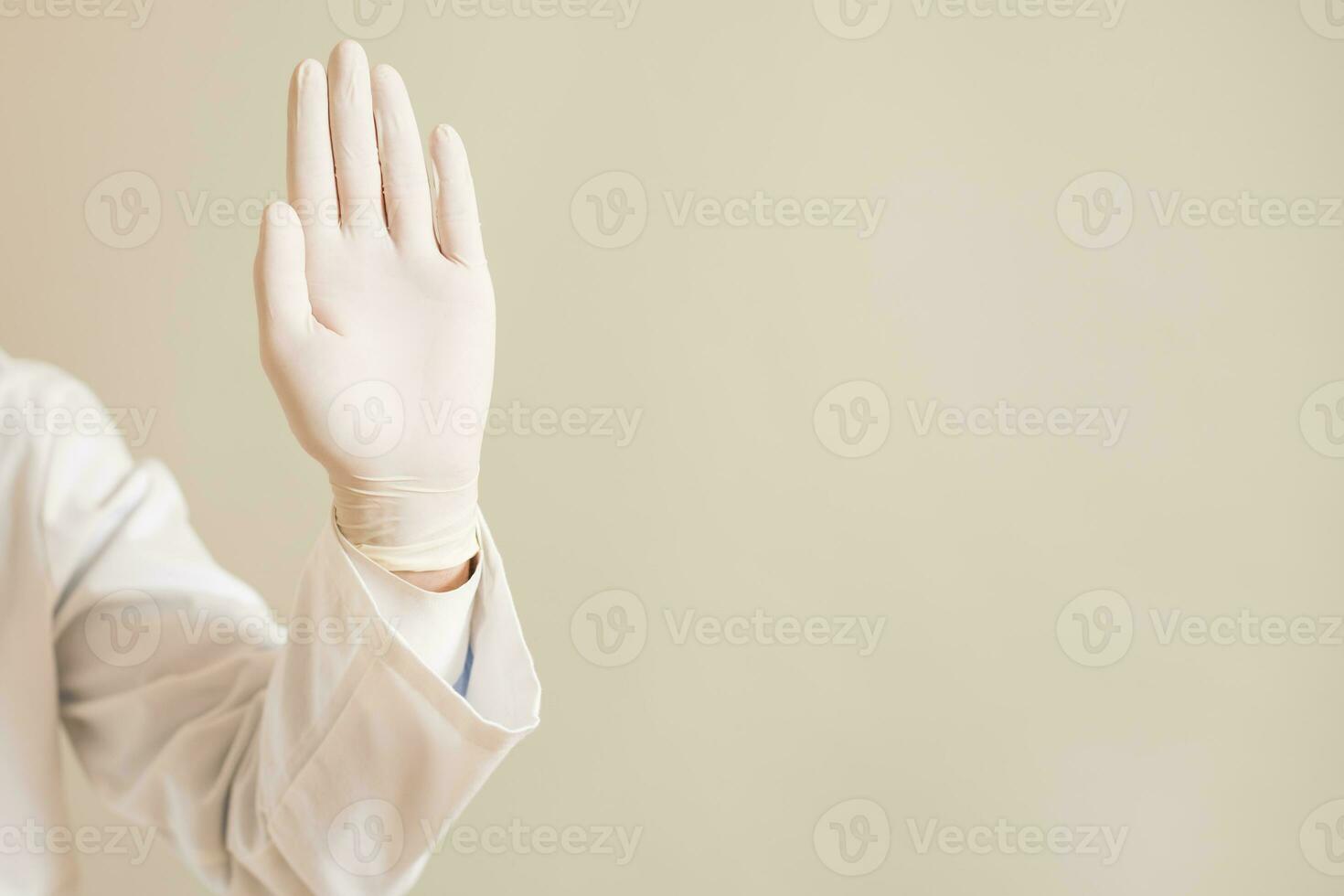 Image of close up hand in protective glove of doctor showing stop sign photo