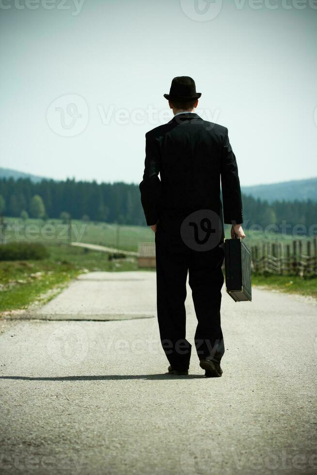 hombre en un traje y sombrero caminando abajo un carretera.tonificada imagen. foto