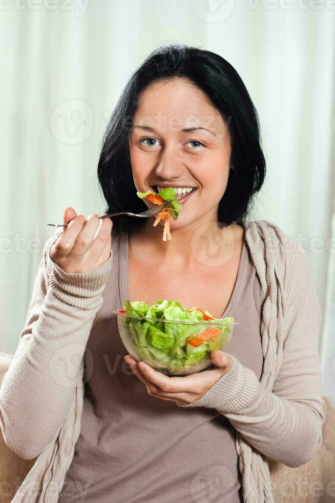 Woman enjoys eating salad photo