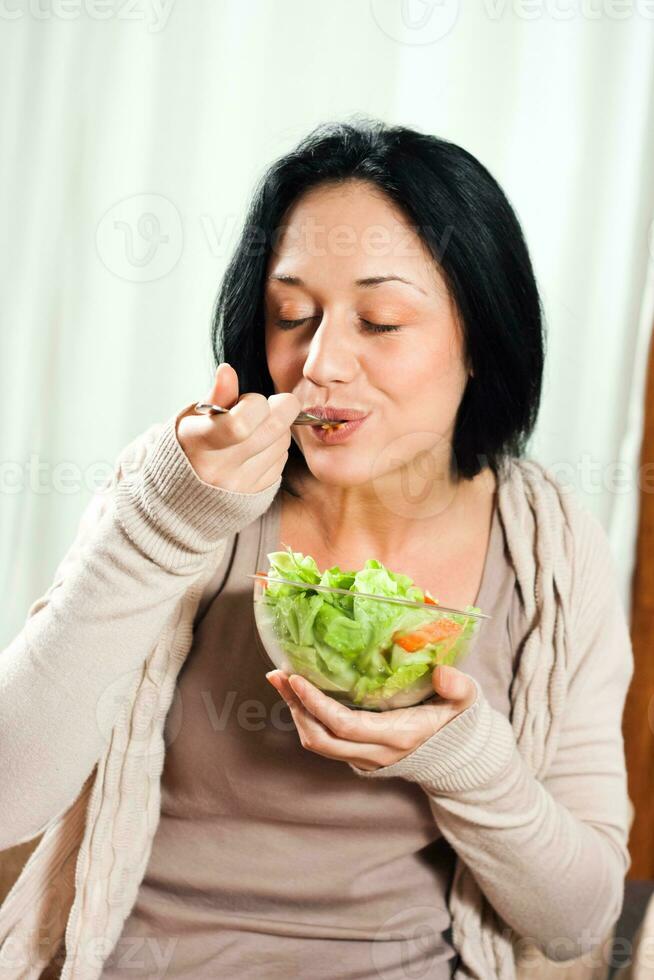 mujer disfruta comiendo ensalada foto