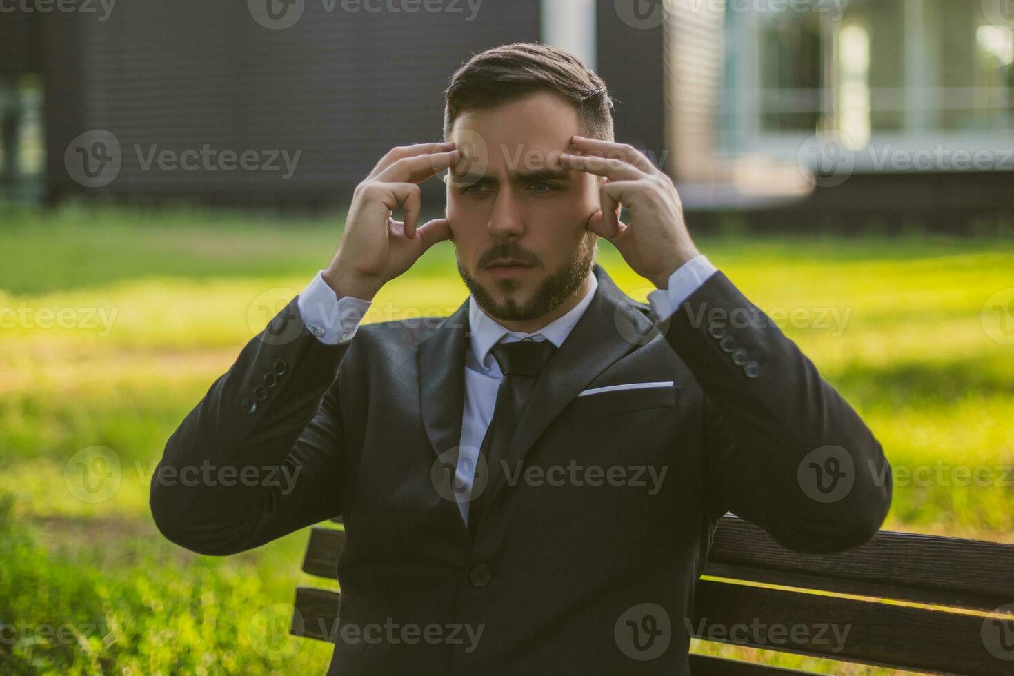 Elegant businessman having a headache while sitting outdoor.Toned image. photo