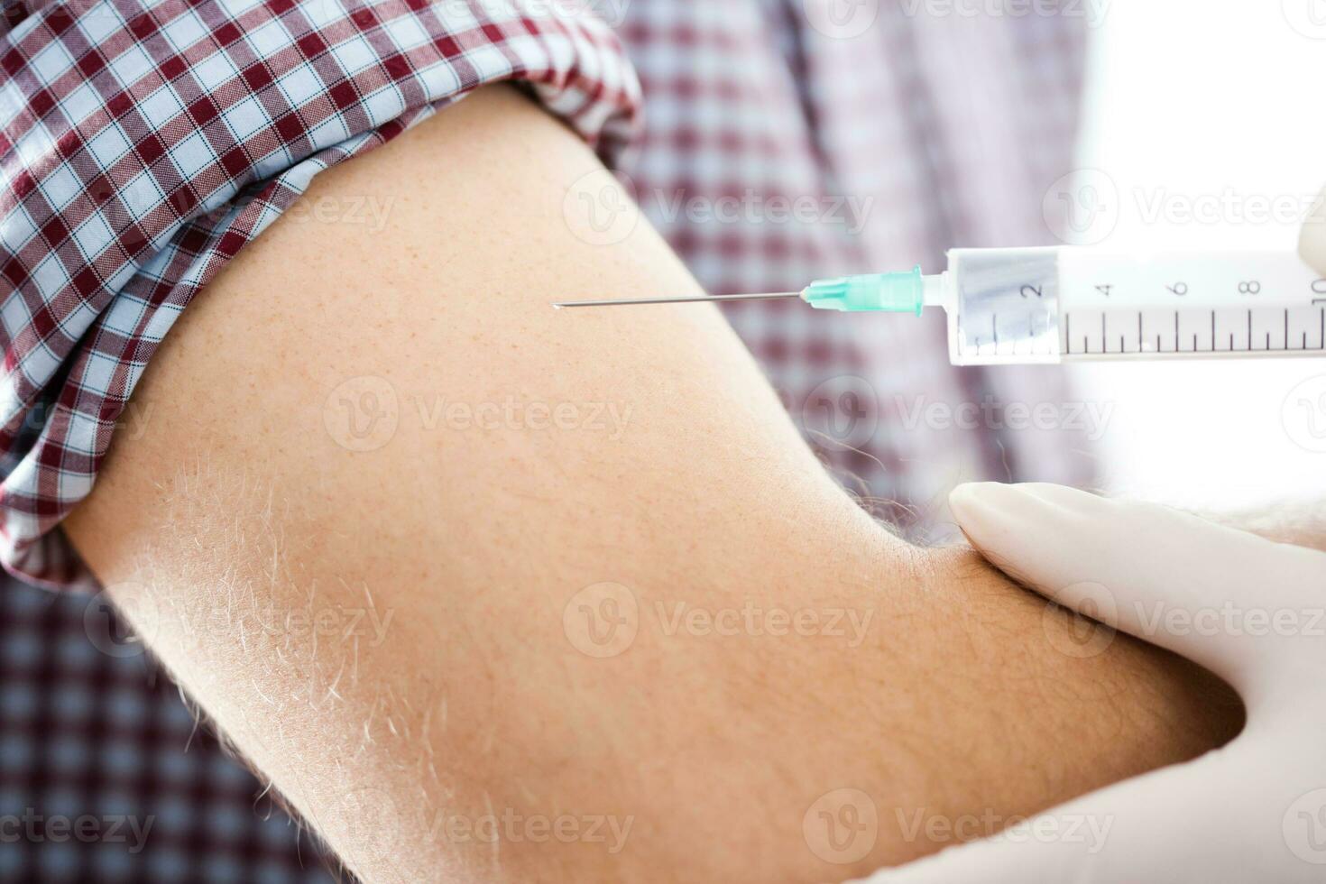 Close up image of doctor giving  getting an injection in the arm photo