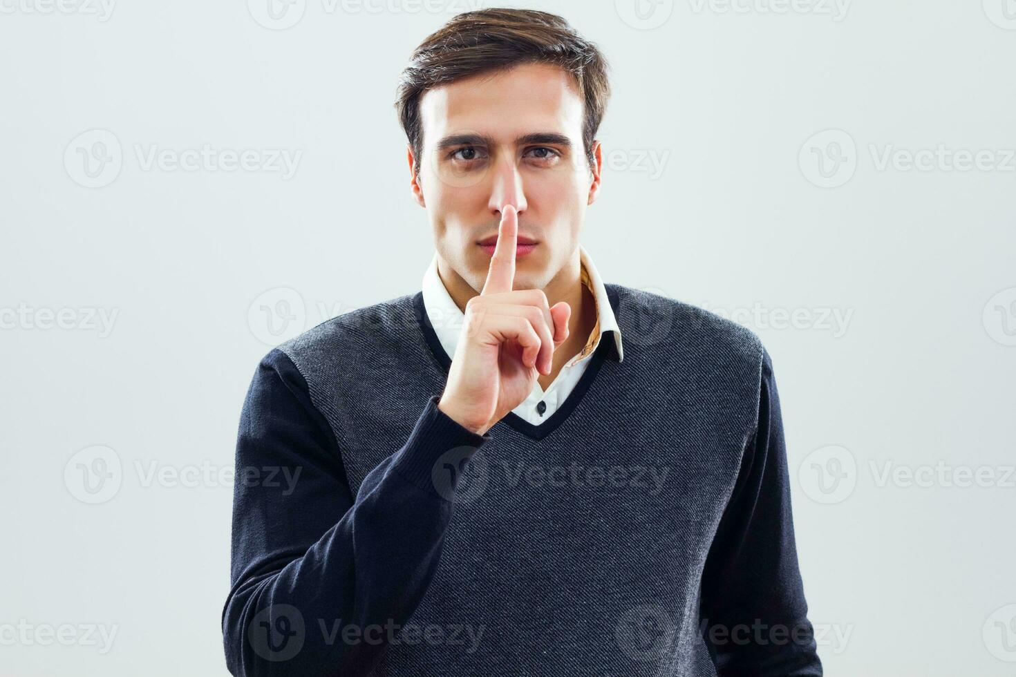 Businessman with finger on his lips photo