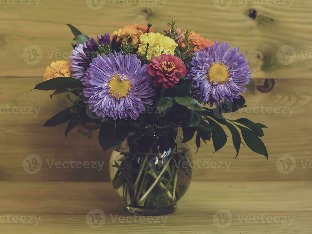 Image of vase with beautiful flowers on wooden background. photo