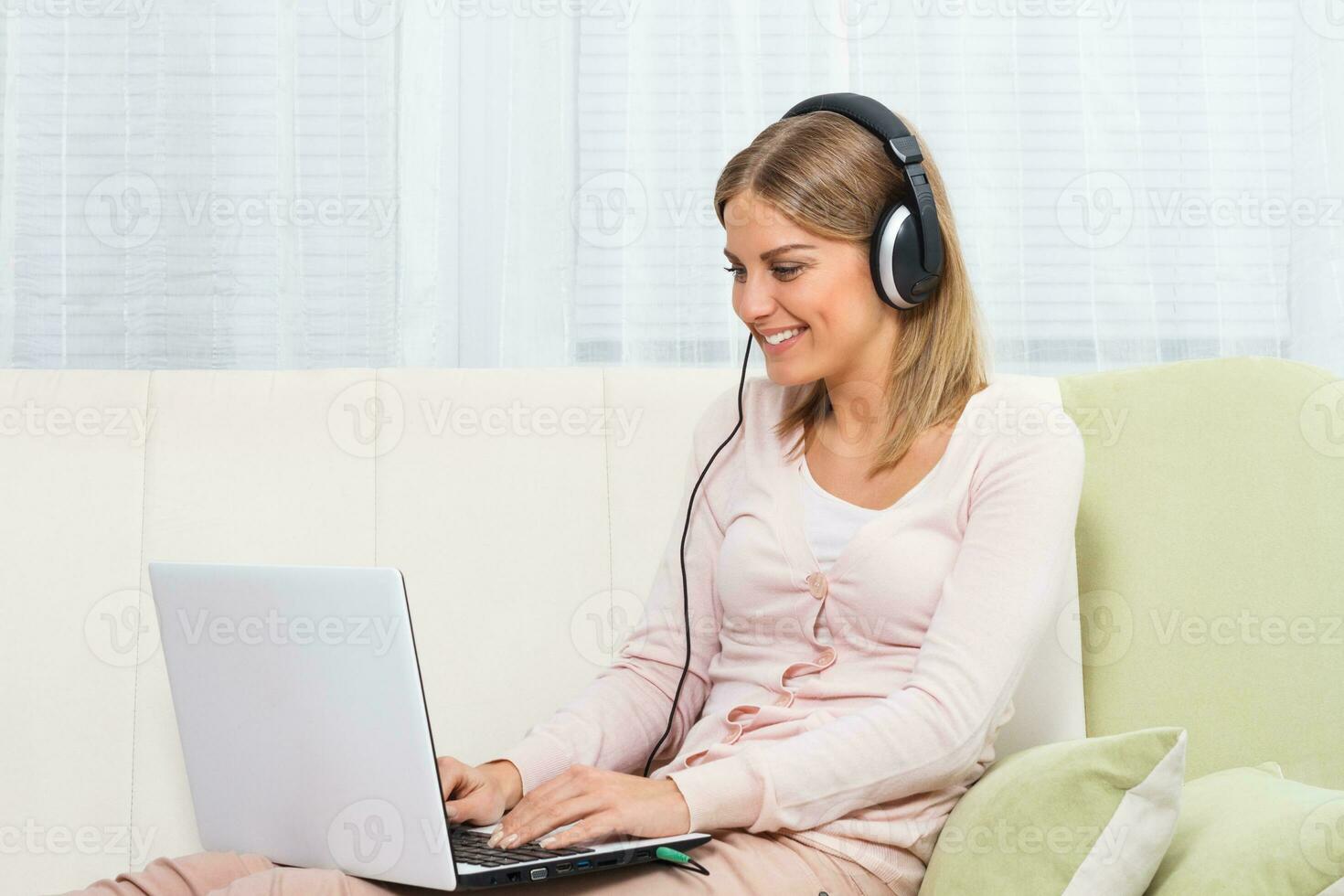 Woman with headphones using laptop photo