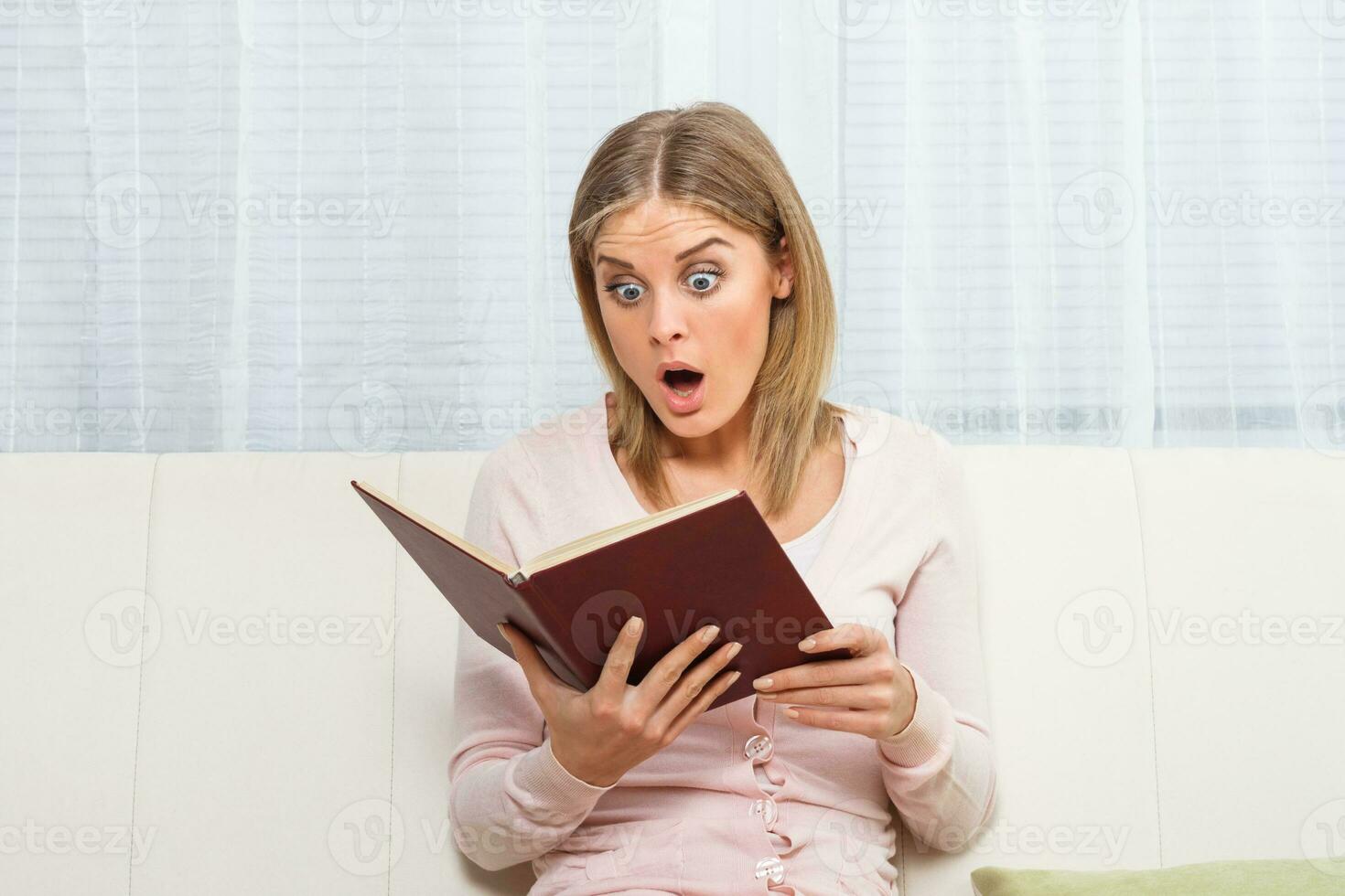 Surprised woman reading book photo