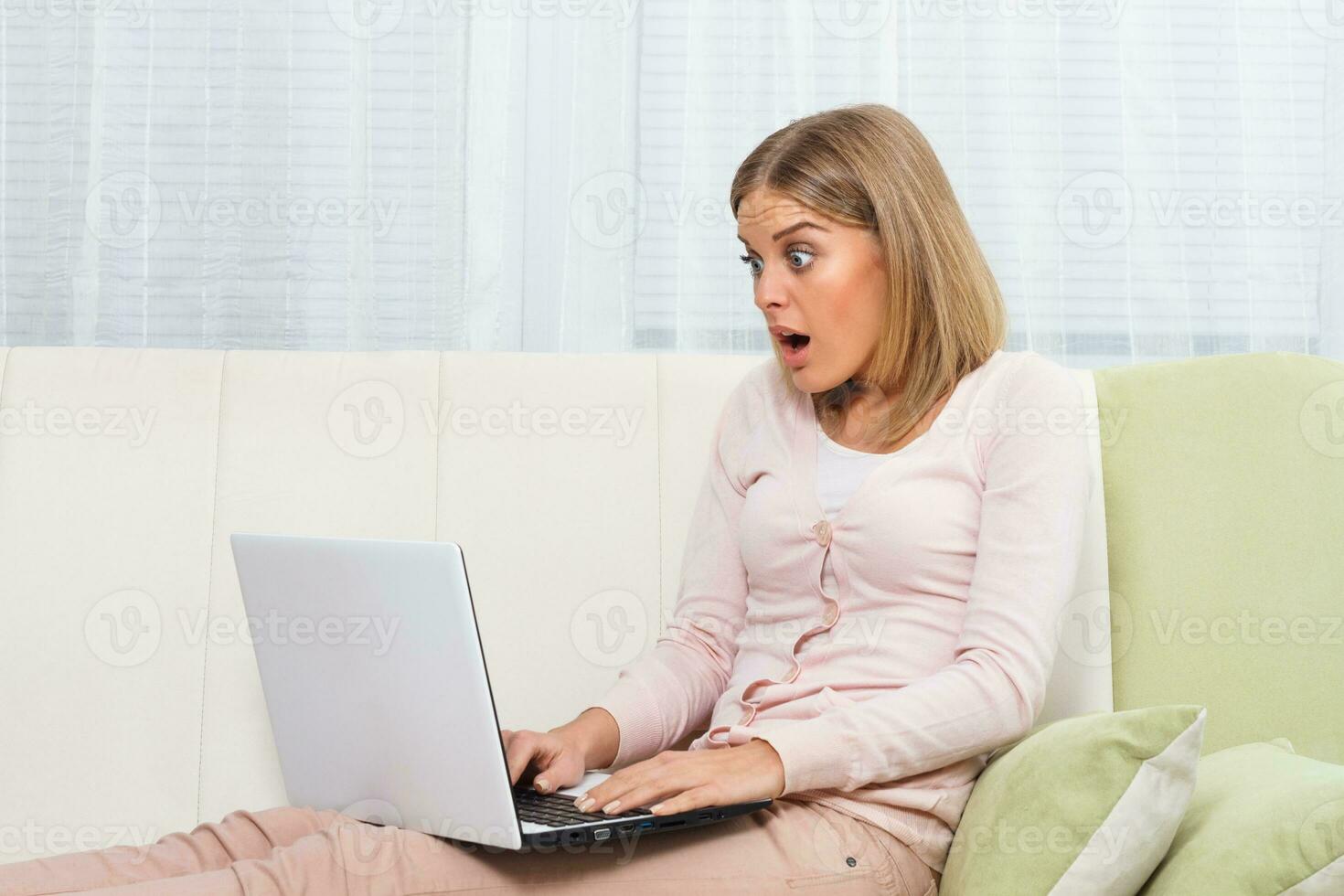 Shocked woman using laptop photo