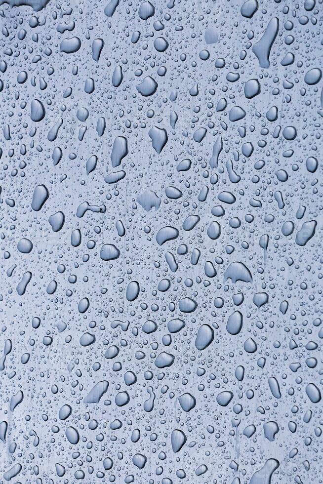 raindrops on the window in rainy days, abstract and blue background photo