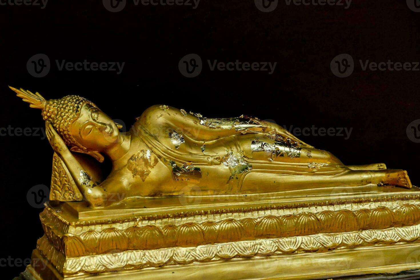 a gold statue of a sleeping buddha photo