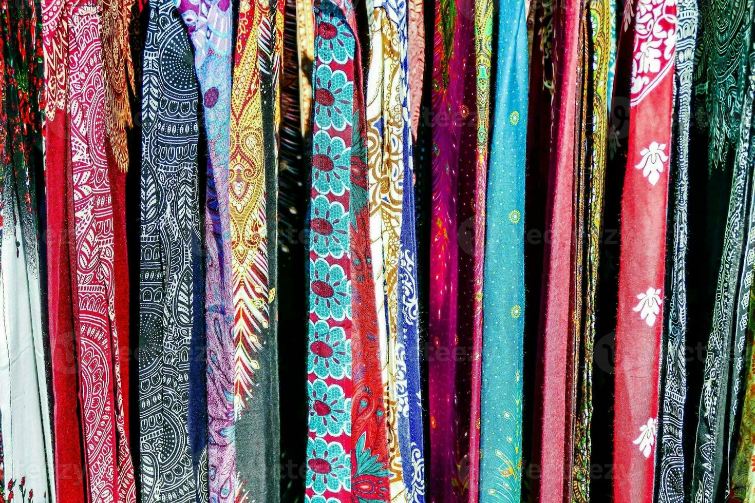 a row of colorful scarves hanging on a rack photo