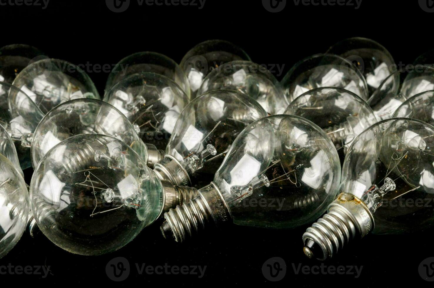 a group of clear light bulbs on a black surface photo