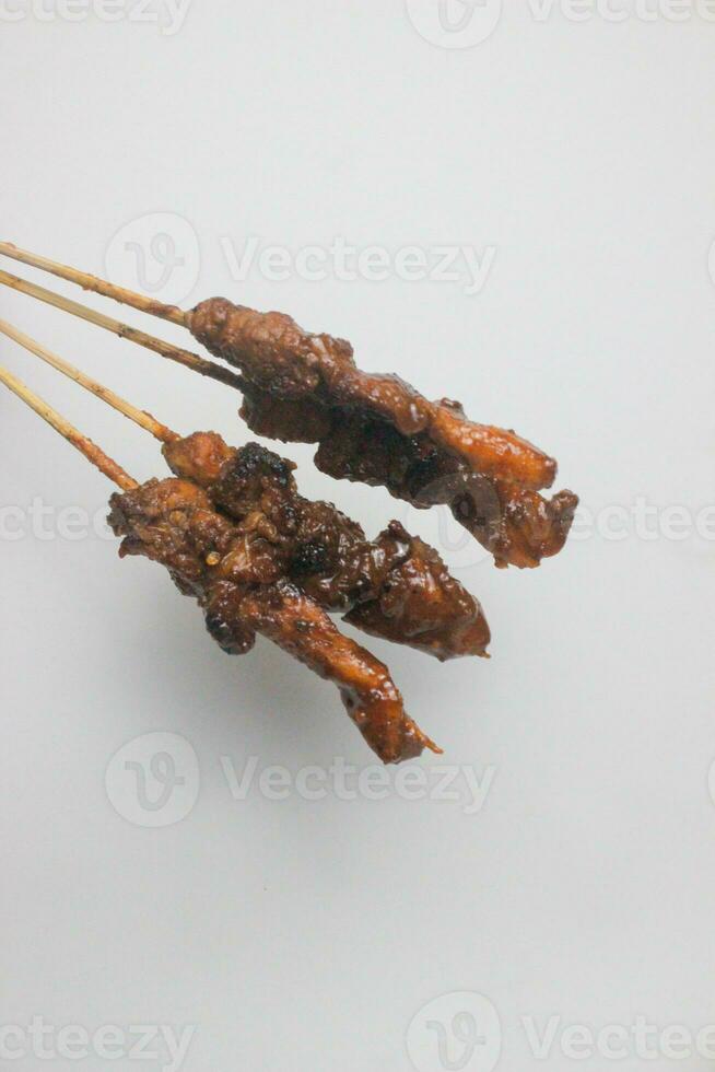 Traditional skewered satay topped with spicy peanut sauce photo