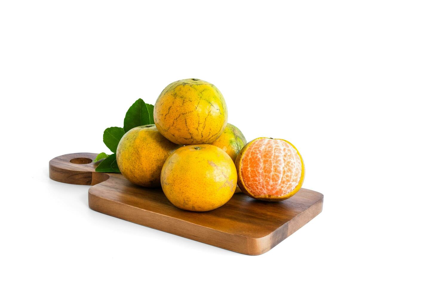 Fresh organic tangerine shogun orange fruit with green leaves, orange flesh visible. On a wooden cutting board. Isolated on white background. photo