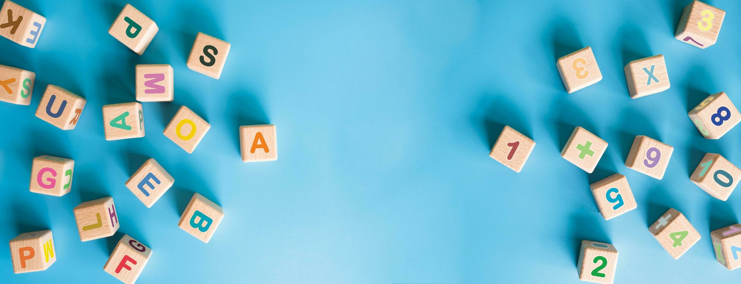 Colorful wooden cubes with letter, numbers scattered on blue background. learning, increasing IQ, development for children. Top view of children's toys. Educational games. photo