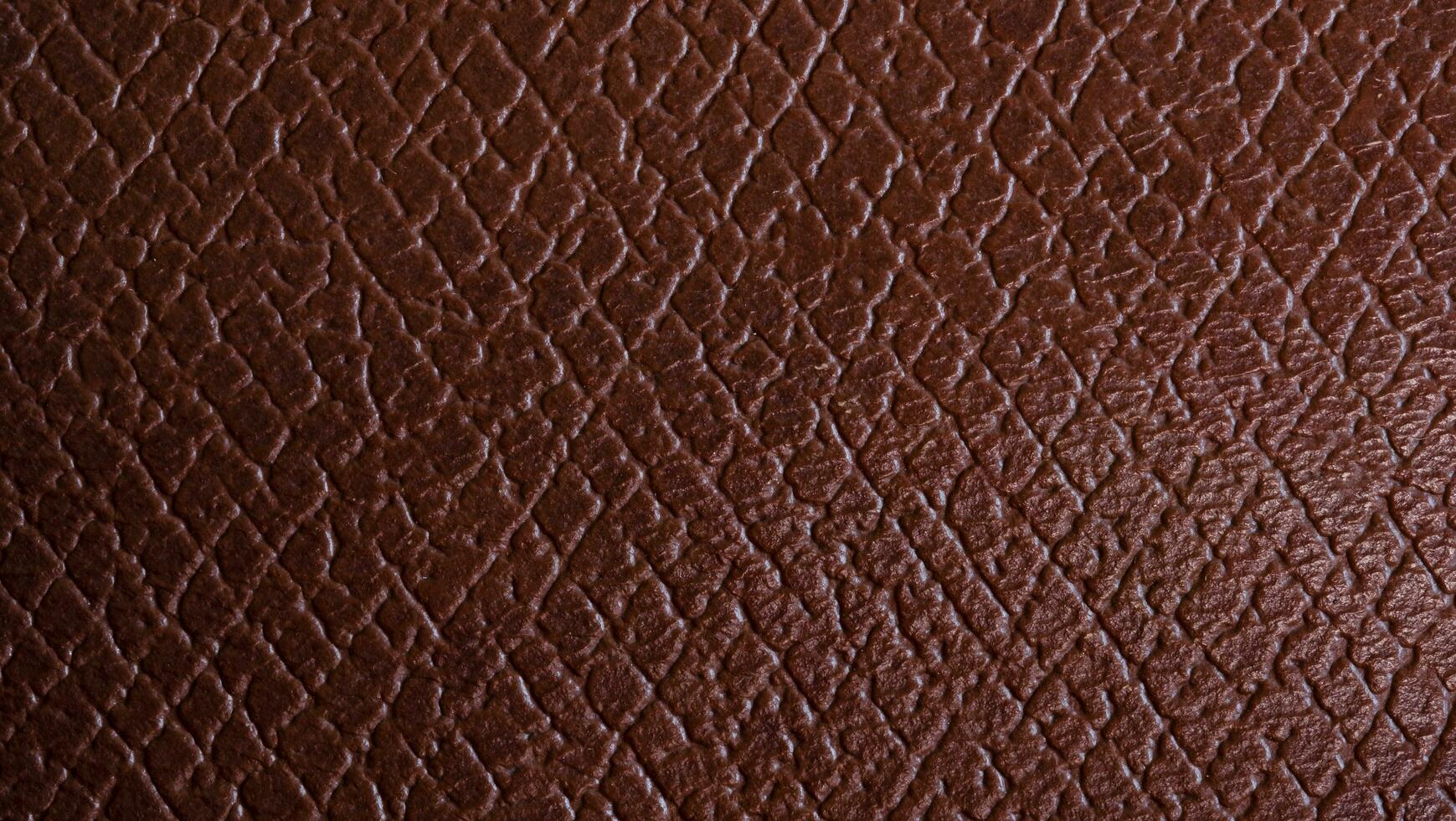 Close-up genuine leather texture, square checkered. Reddish brown color, natural wrinkled texture wallpaper pattern. leather accessory production concept. photo