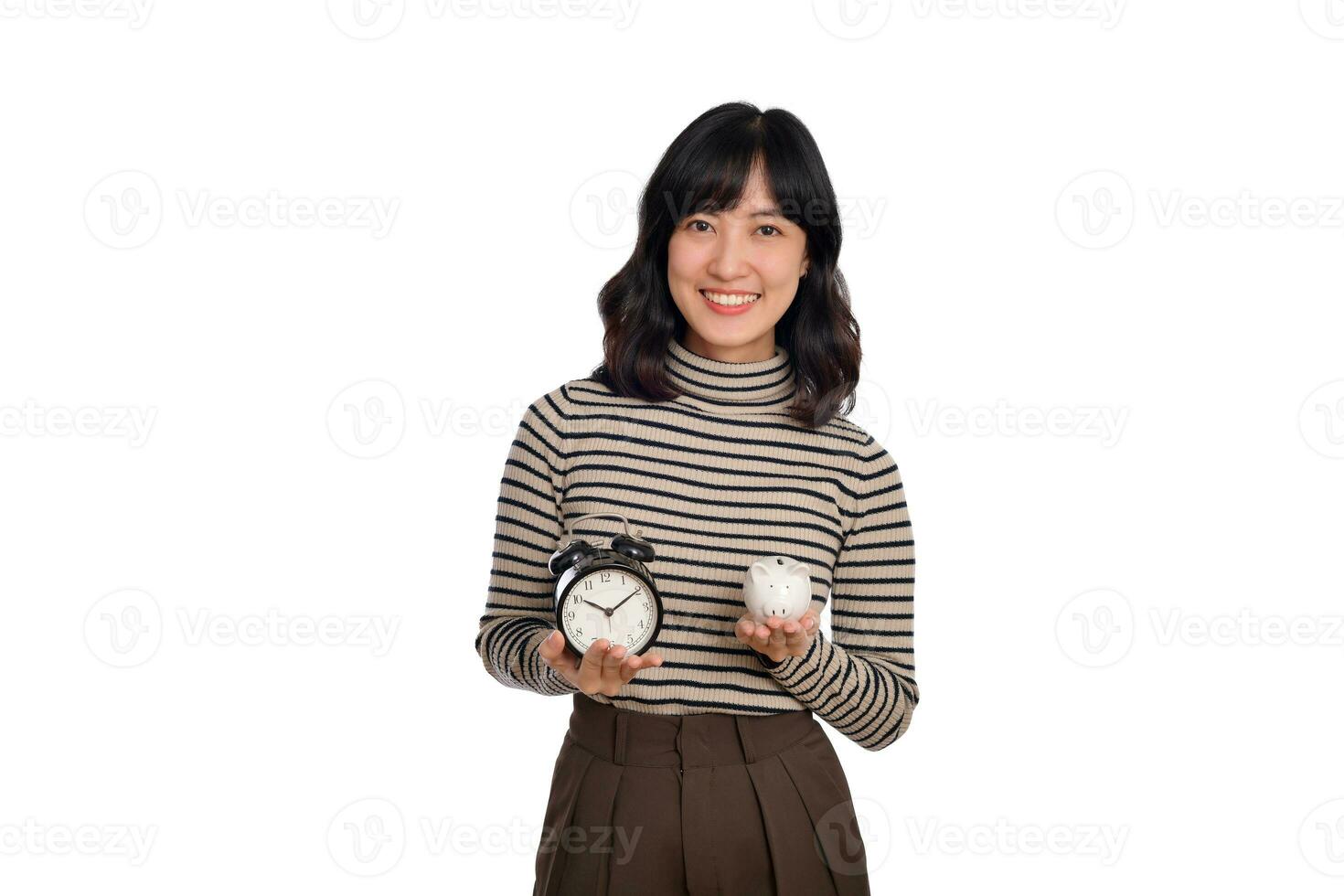 Happy Asian woman with sweater shirt holding alarm clock and piggy bank isolated on white background photo