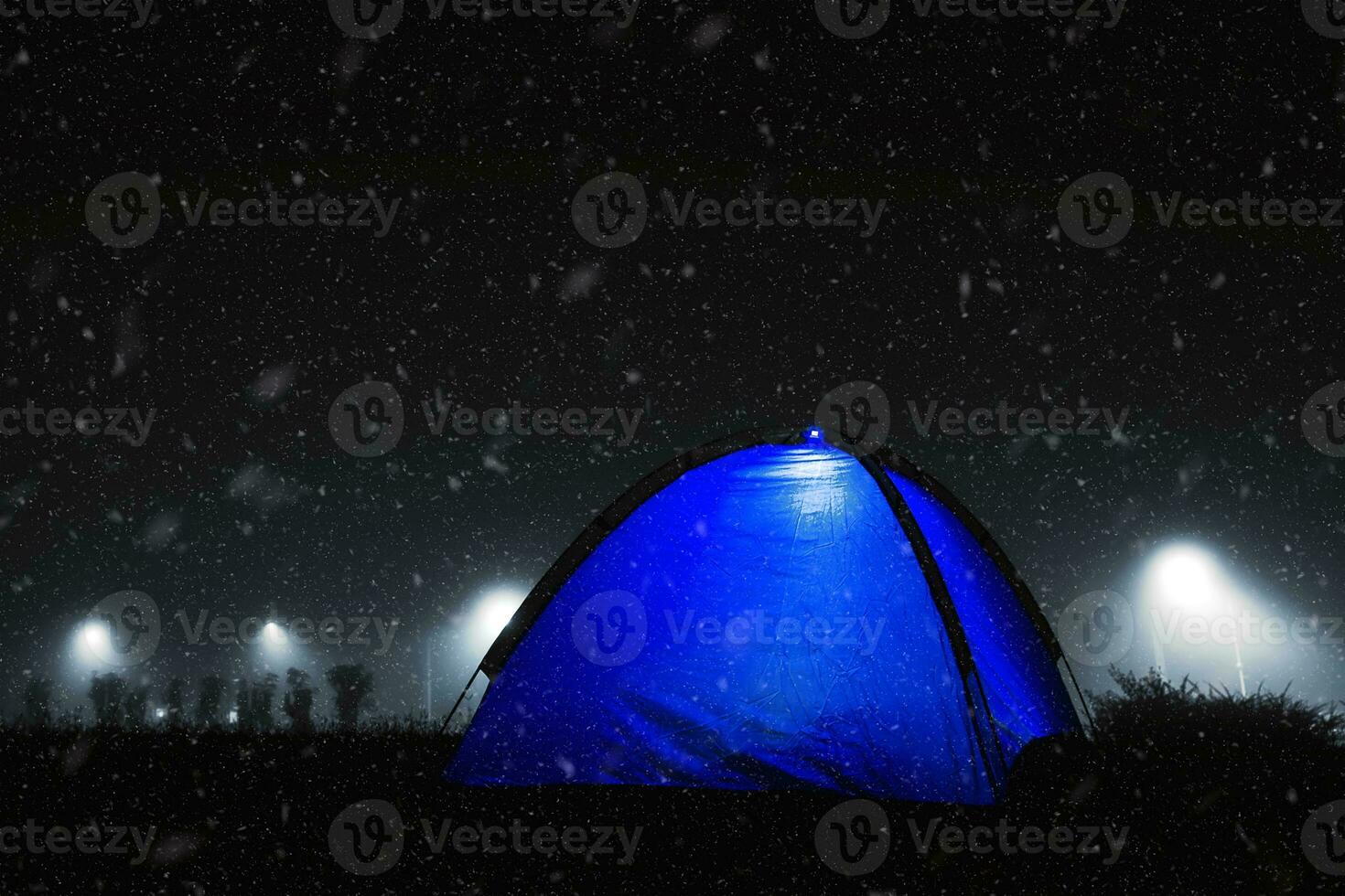 Blue tent with light in the winter snow. photo