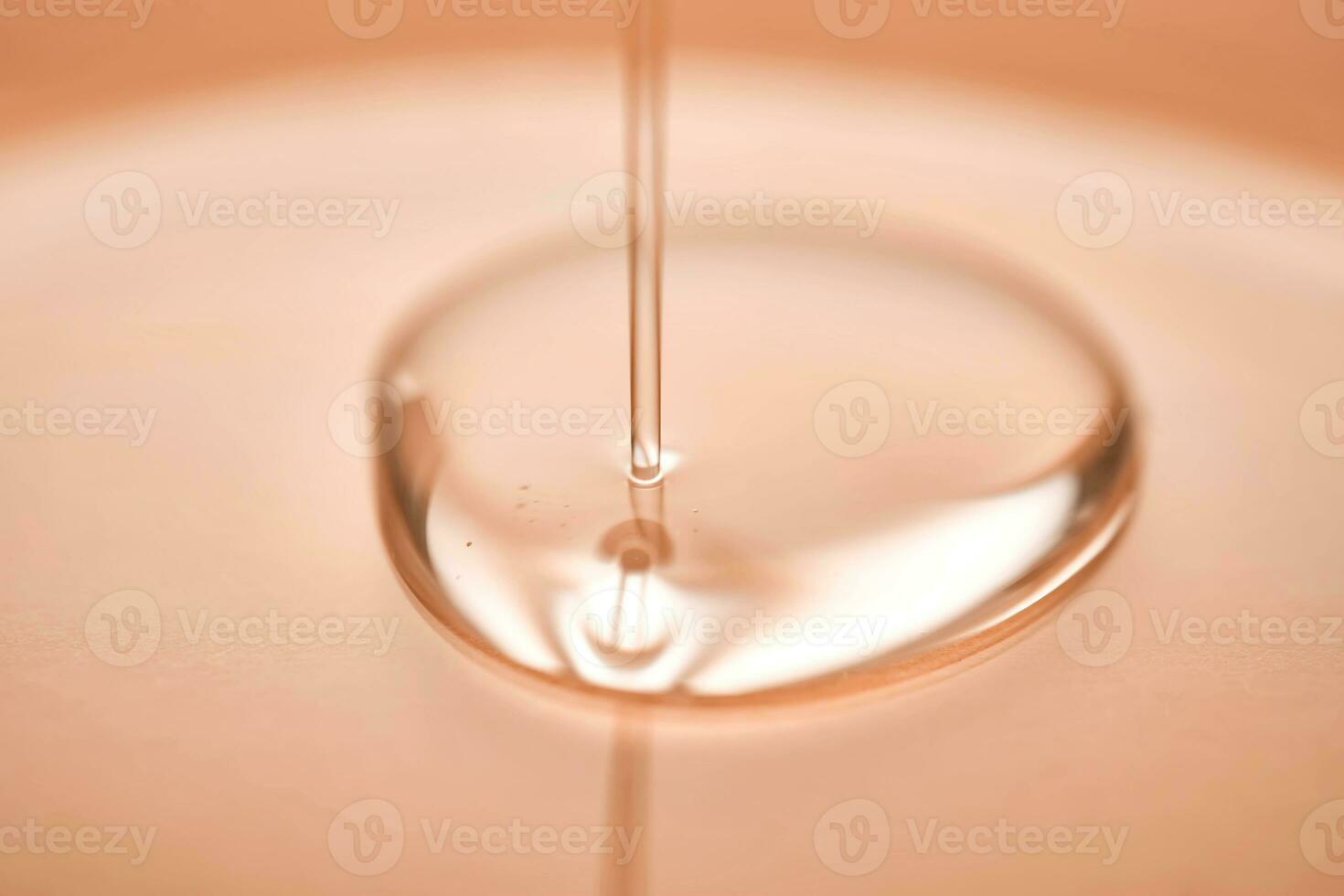 A juicy drop of gel on a Peach Fuzz background. photo