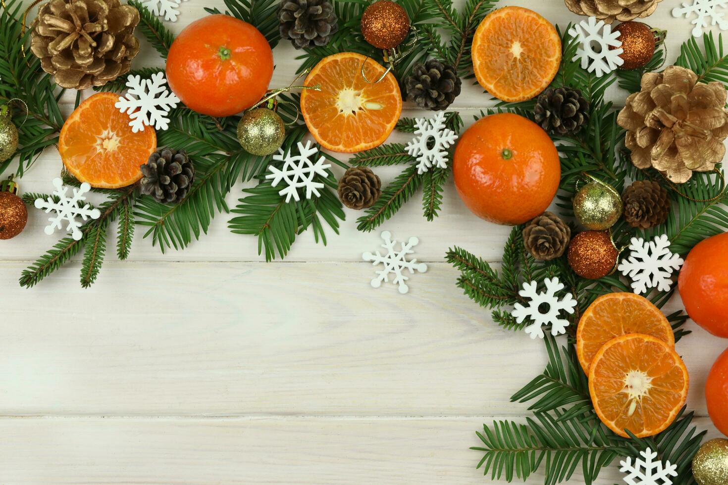 white wooden winter background with christmas decorations, tangerines, cones and copy space photo