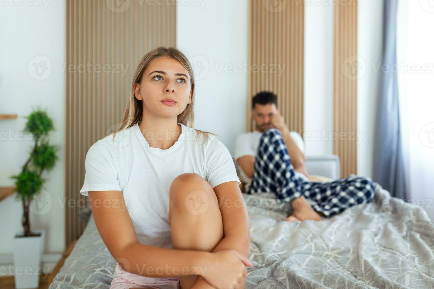 Frustrated sad girlfriend sit on bed think of relationship problems, thoughtful couple after quarrel lost in thoughts, upset lovers consider break up, offended person disappointed by boyfriend photo