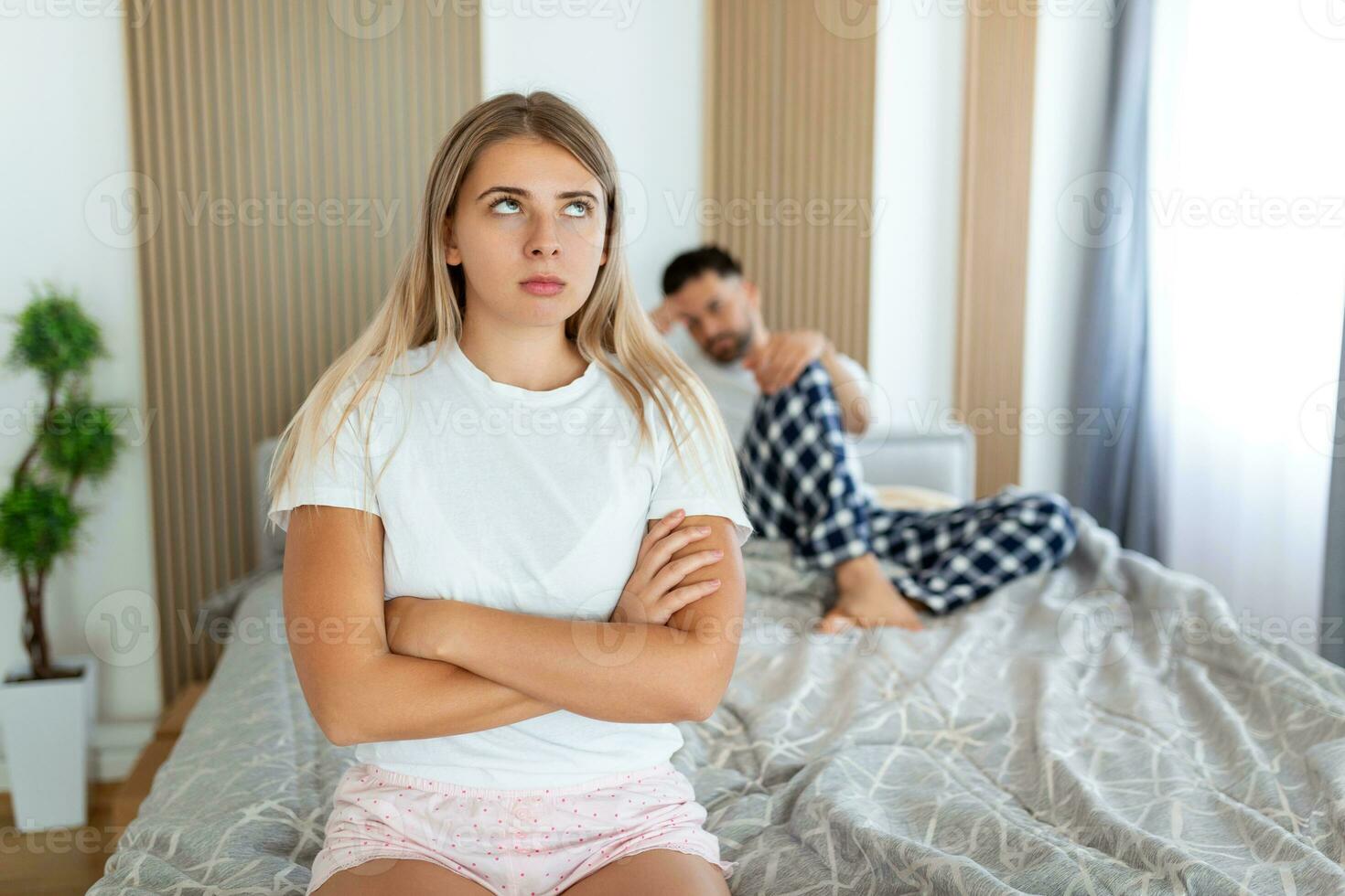 Frustrated sad girlfriend sit on bed think of relationship problems, thoughtful couple after quarrel lost in thoughts, upset lovers consider break up, offended person disappointed by boyfriend photo
