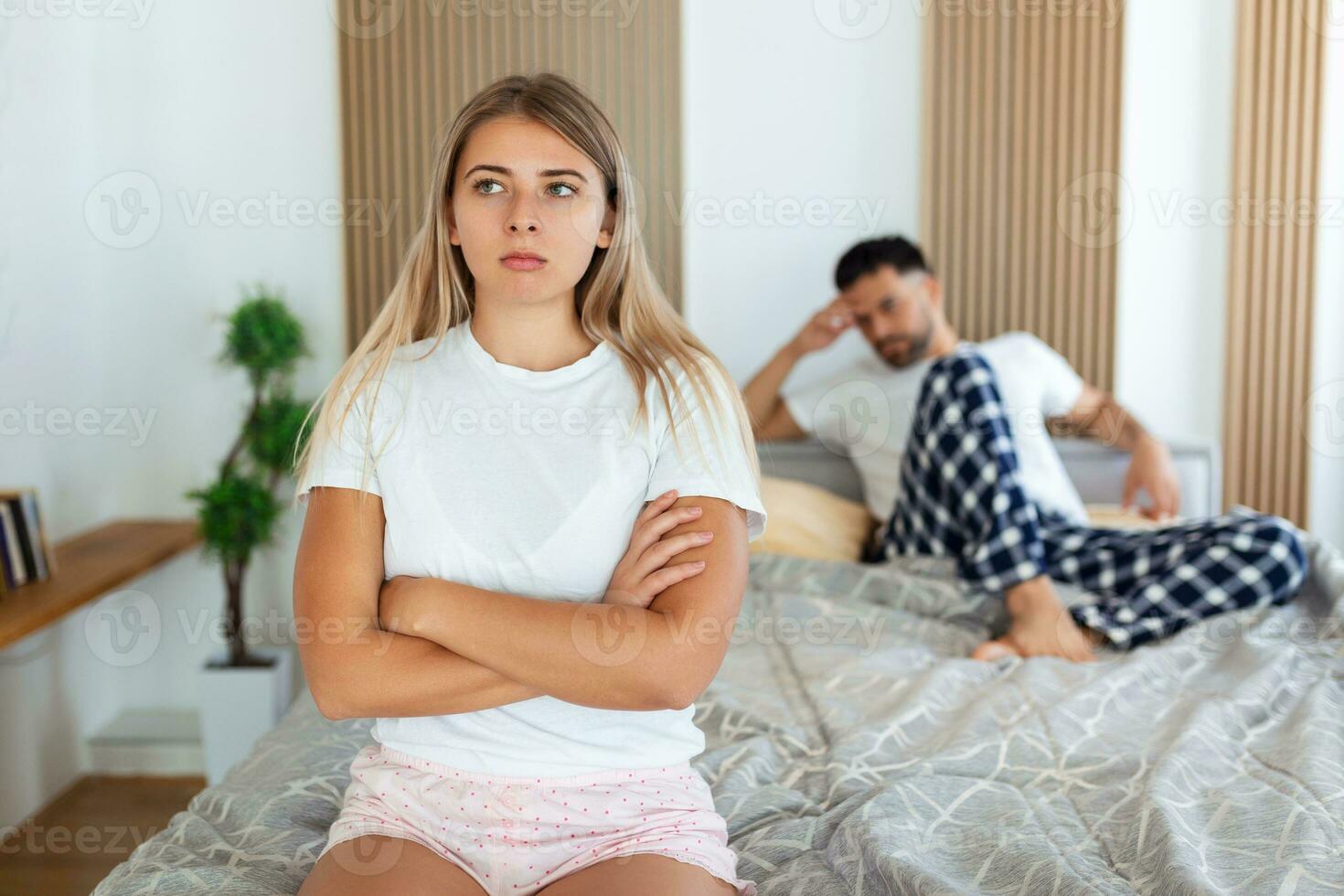 Frustrated sad girlfriend sit on bed think of relationship problems, thoughtful couple after quarrel lost in thoughts, upset lovers consider break up, offended person disappointed by boyfriend photo