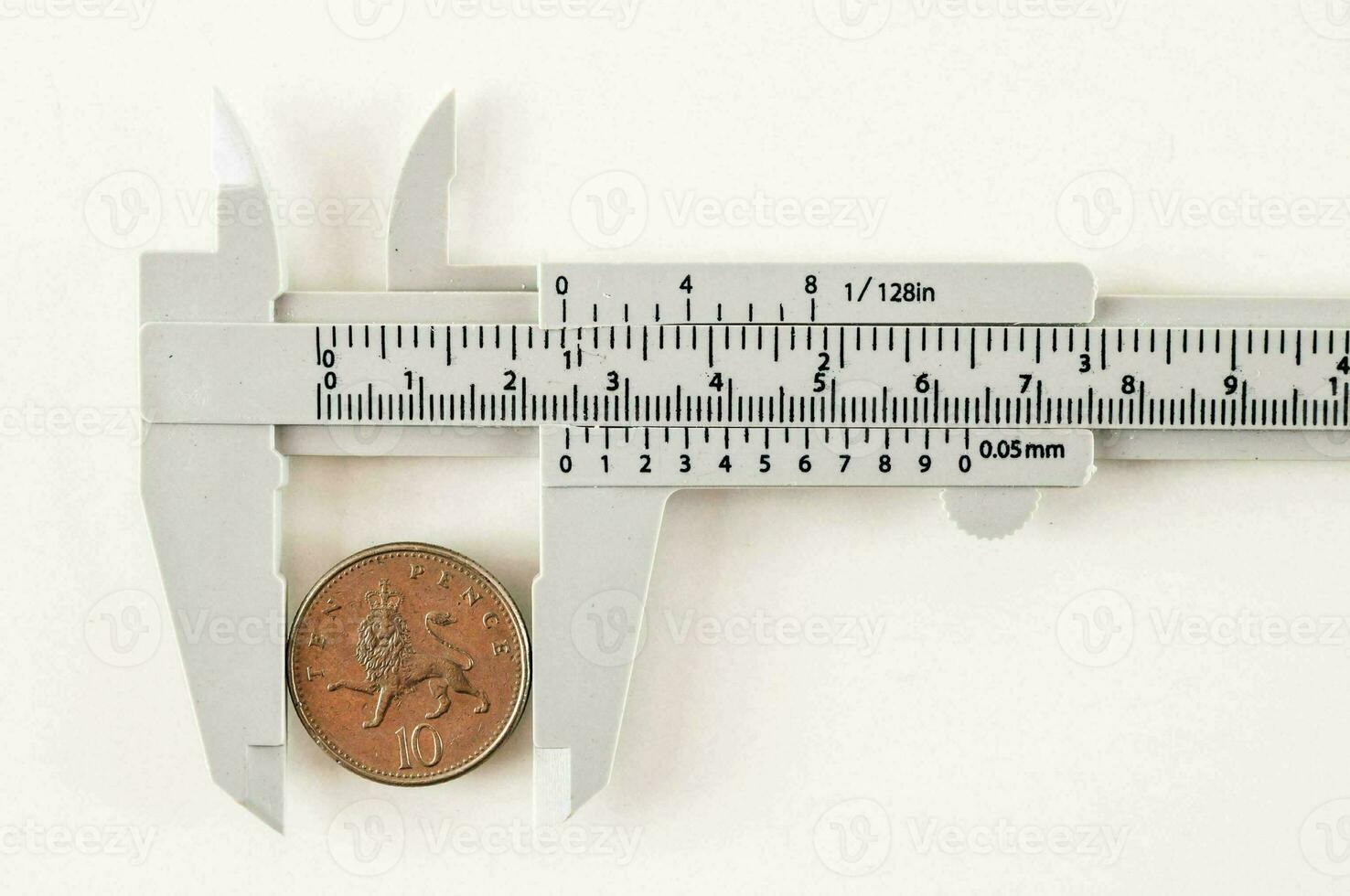 a caliper is holding a penny on a white surface photo