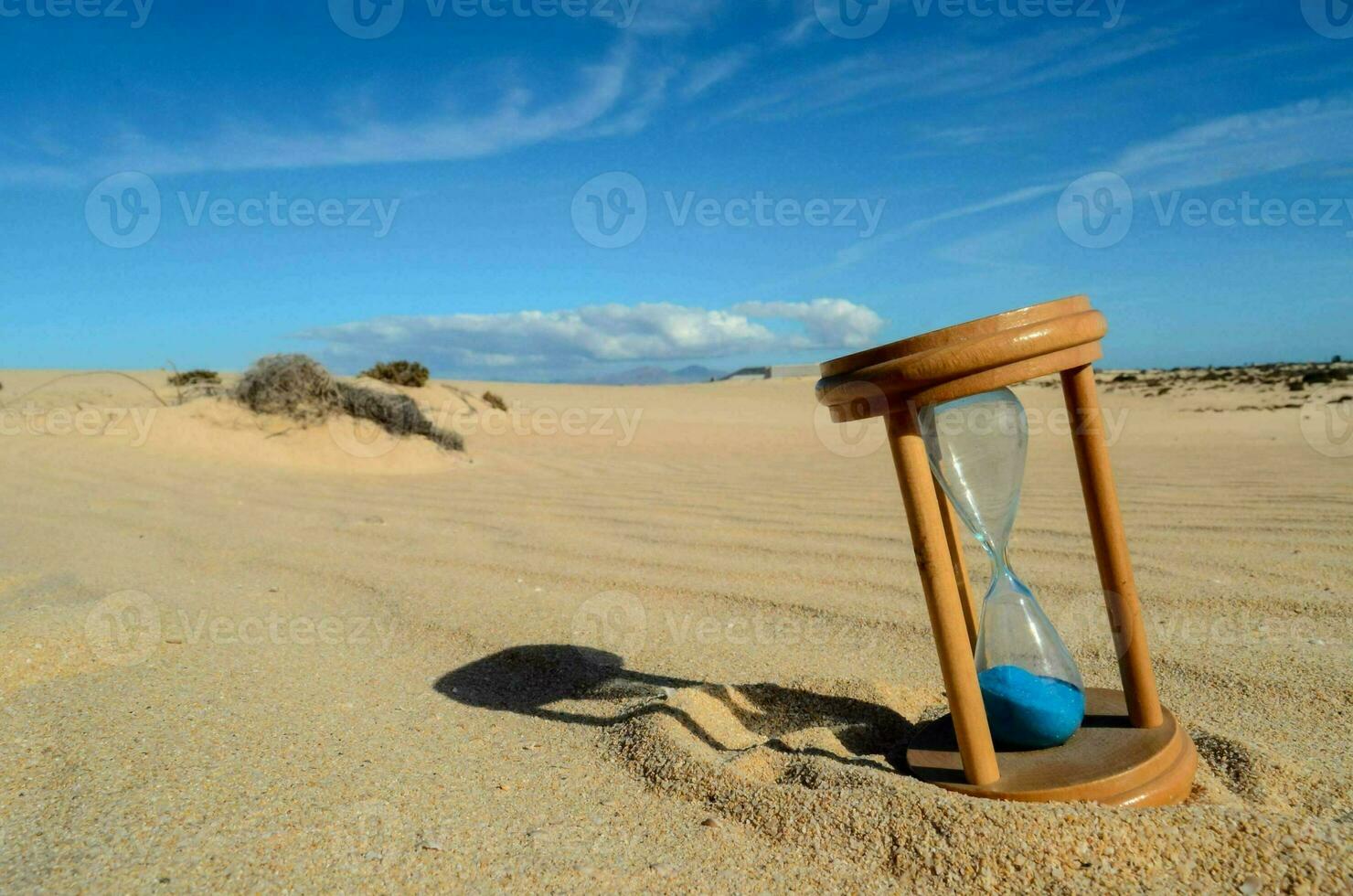 an hourglass on the beach sand photo