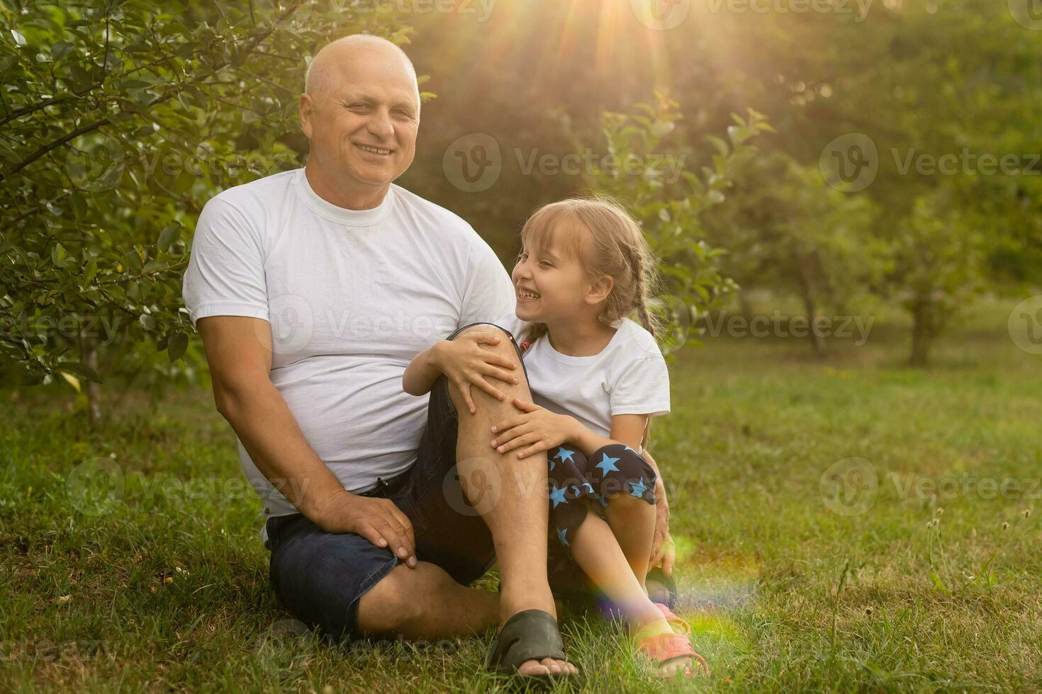 retrato de abuelo con nieta relajante juntos en el jardín foto