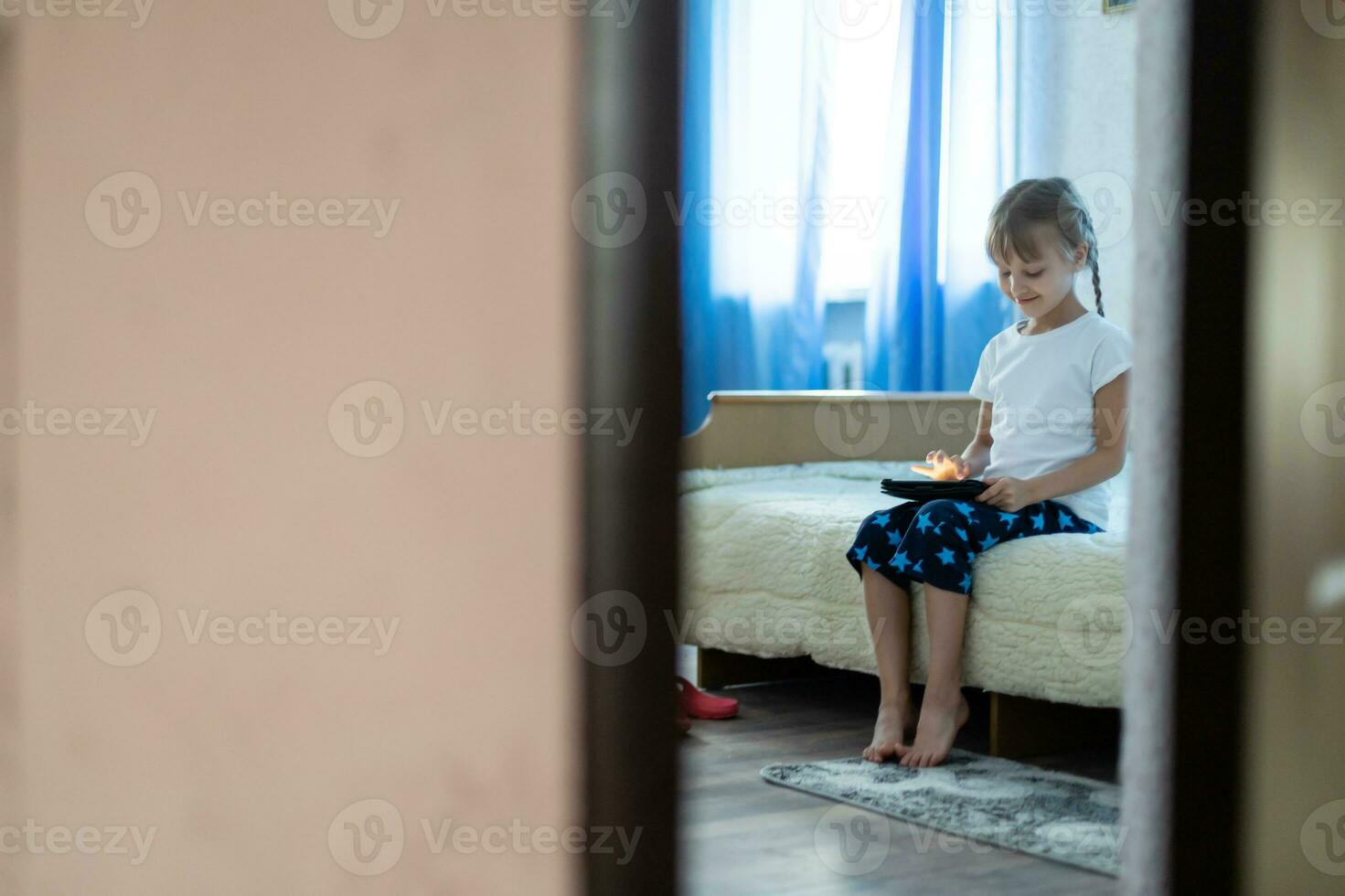 Remote lessons. The child smiles happily and gets knowledge remotely. Little girl study online learning from home with laptop. Online school. photo