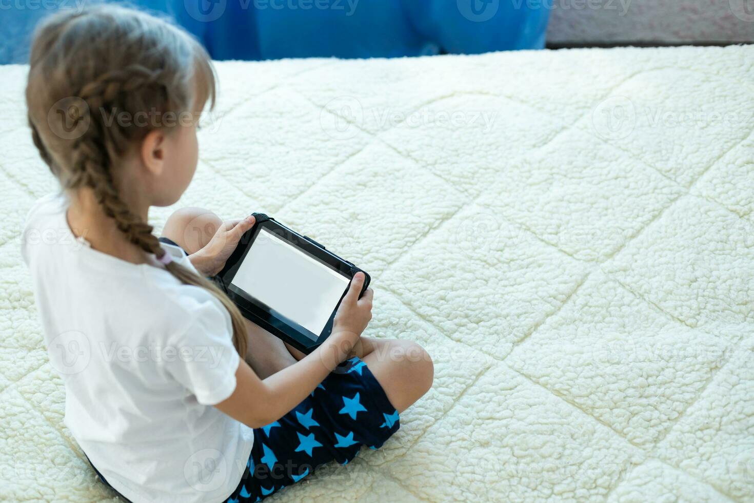 Cute adorable caucasian little blond girl sitting during online video chat school lesson session with teacher and class. Remote education concept. Self-isolation at quarantine photo