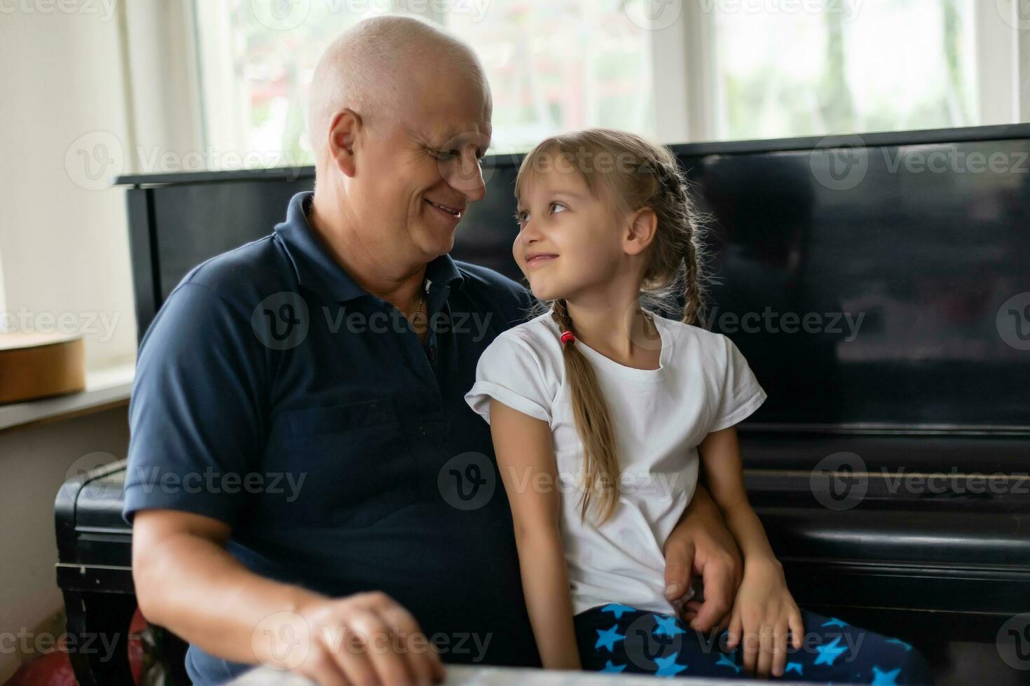 Photo of funny two people old grandpa little interested granddaughter sitting sofa telling good story stay house quarantine safety modern design interior living room indoors