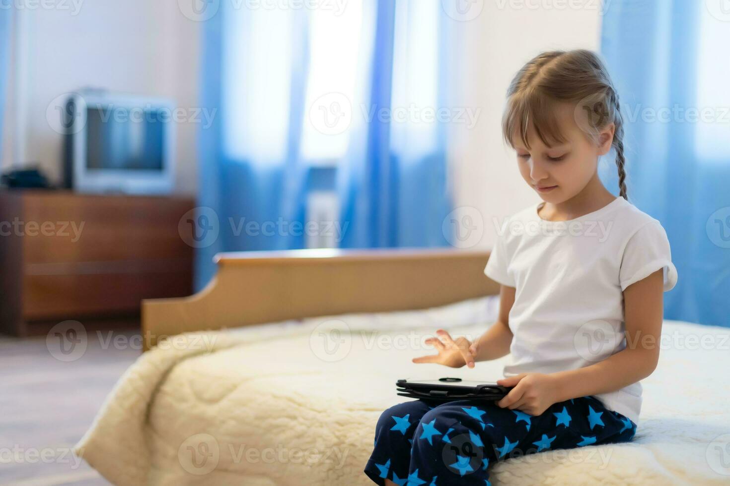 Cute young child using a digital tablet in a home interior photo