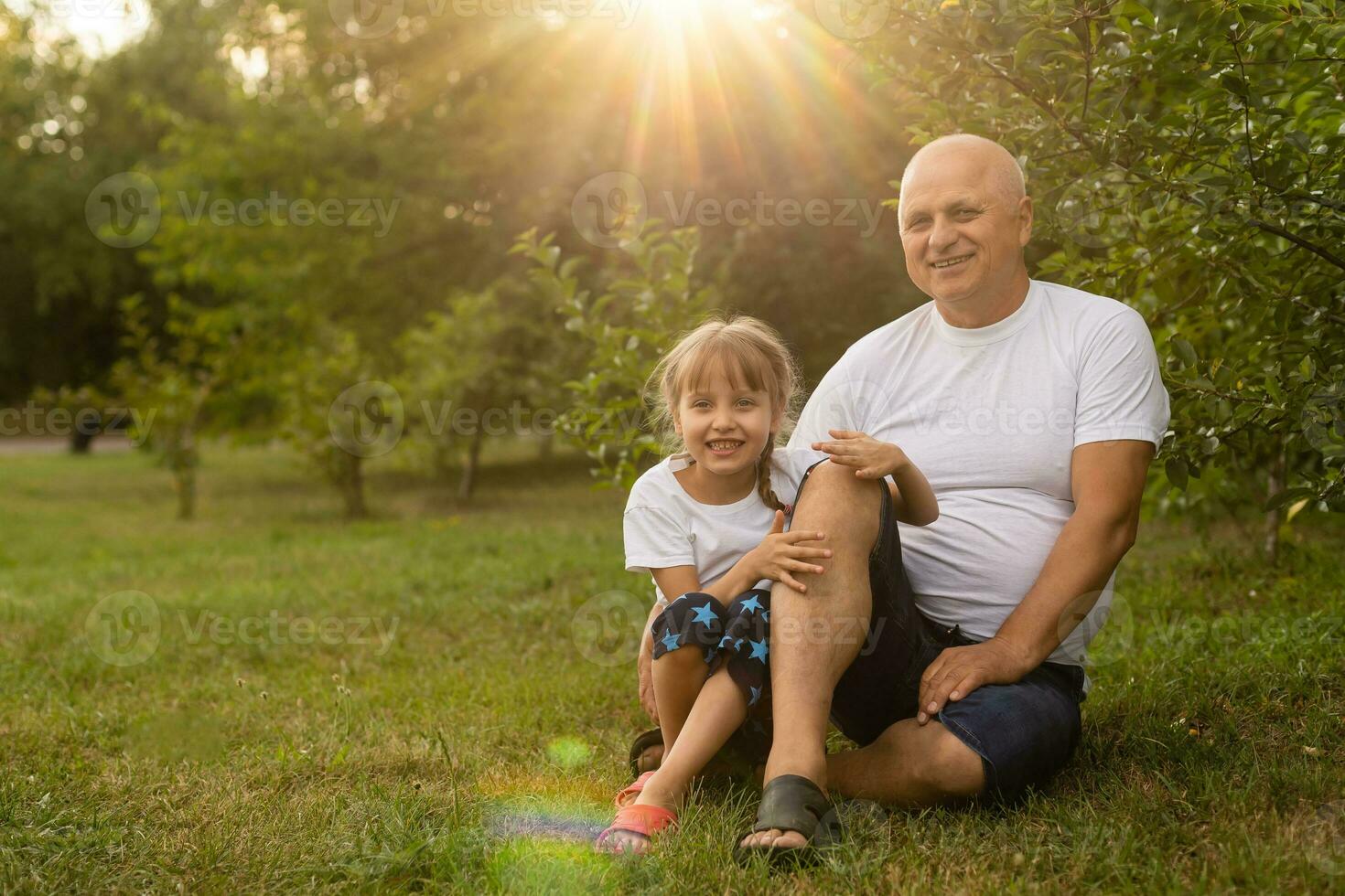 Little girl spending time with grandfather in the park. photo