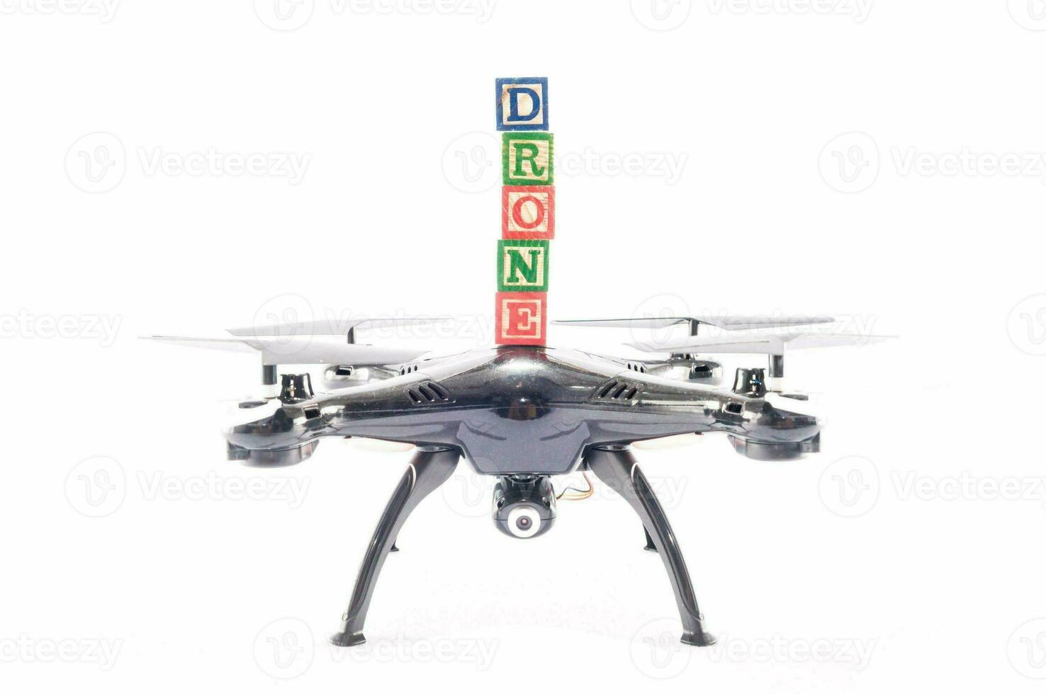 a drone carrying toy blocks spelling the word drone photo