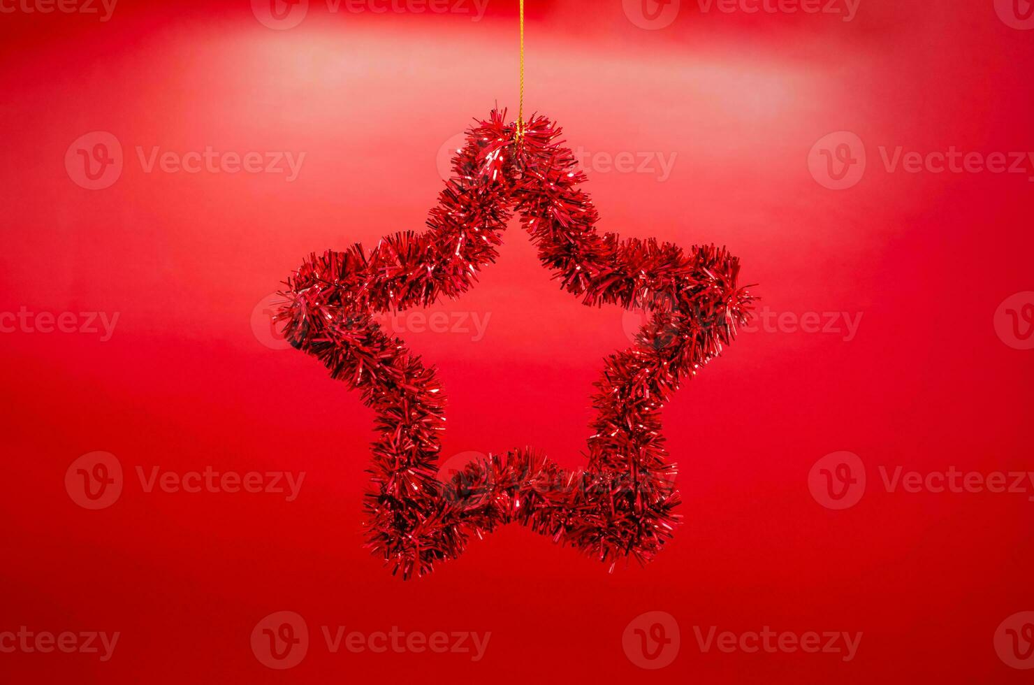 Star shape ornament hanging from top on red background. Minimal Christmas holiday concept. photo