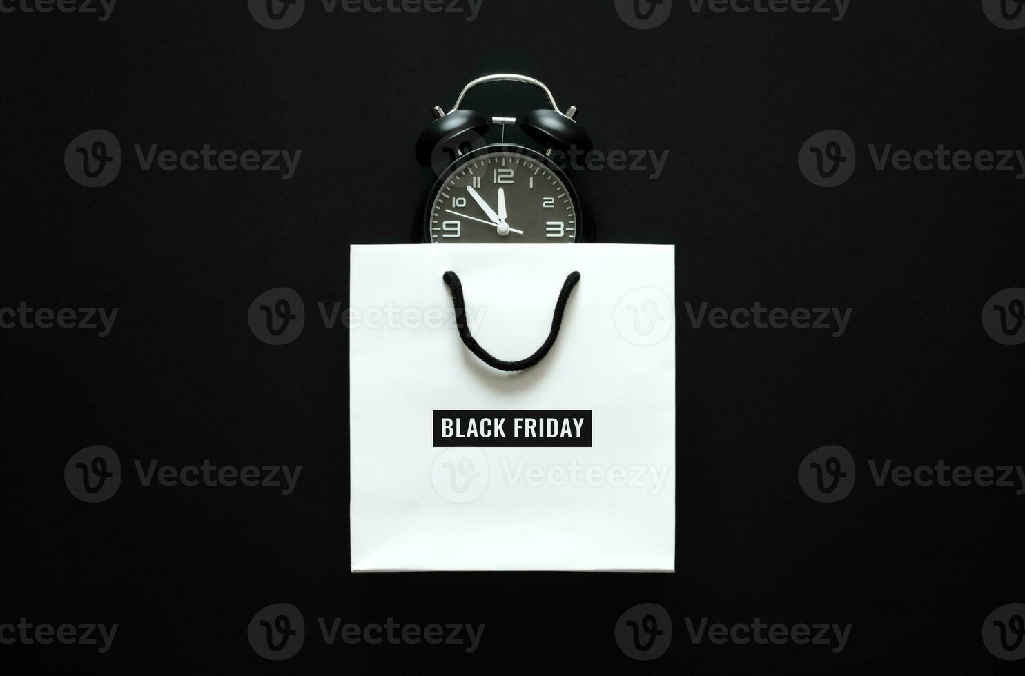 White shopping bag with Black Friday word and alarm clock inside for Black Friday shopping concept. photo
