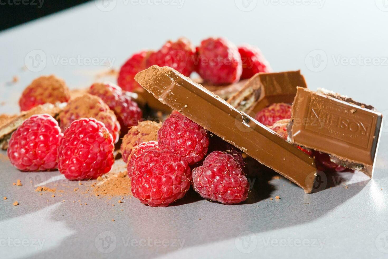raspberries with chocolate on gray photo