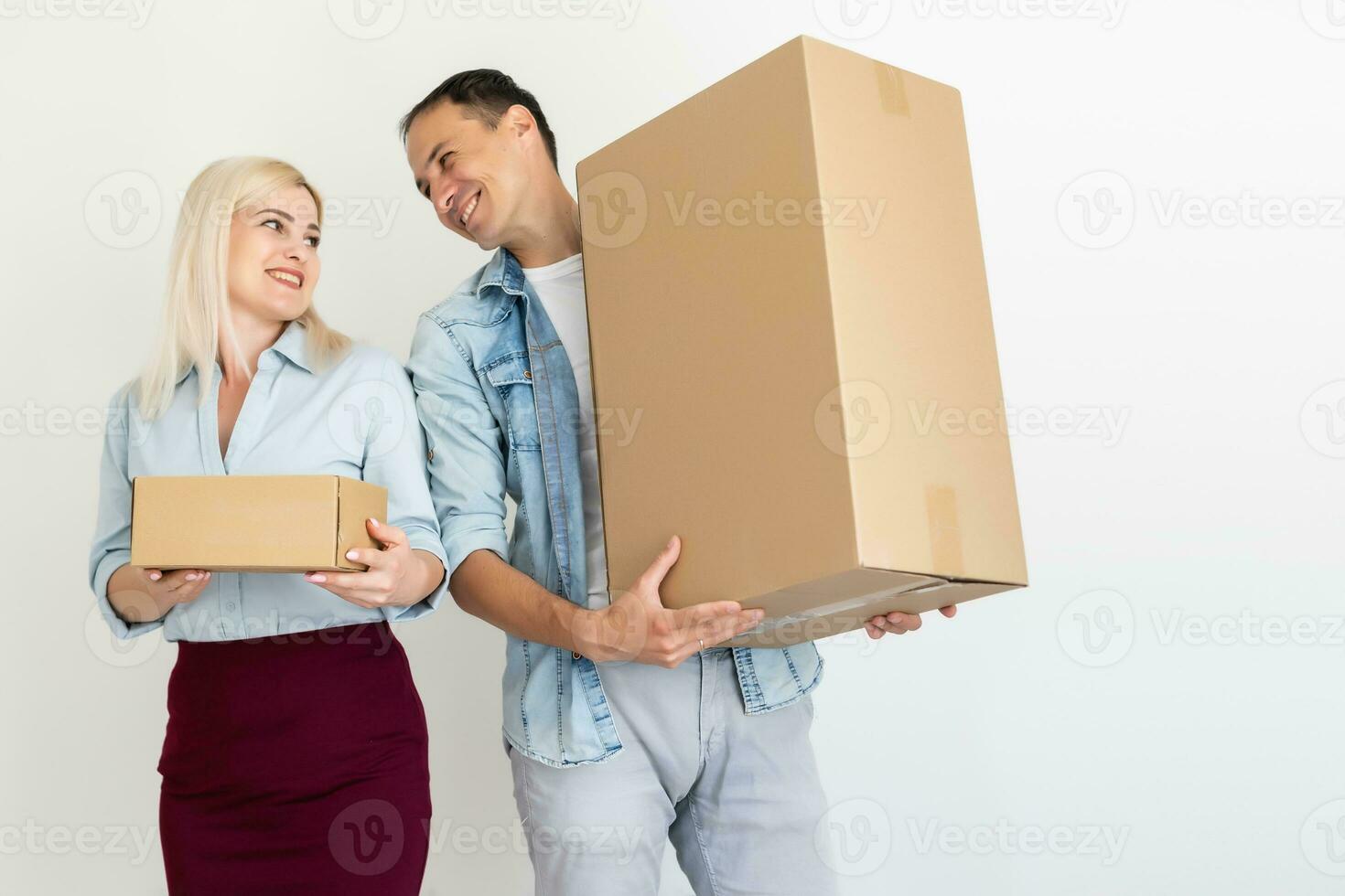moving, home and family concept - smiling couple holding cardboard boxes photo