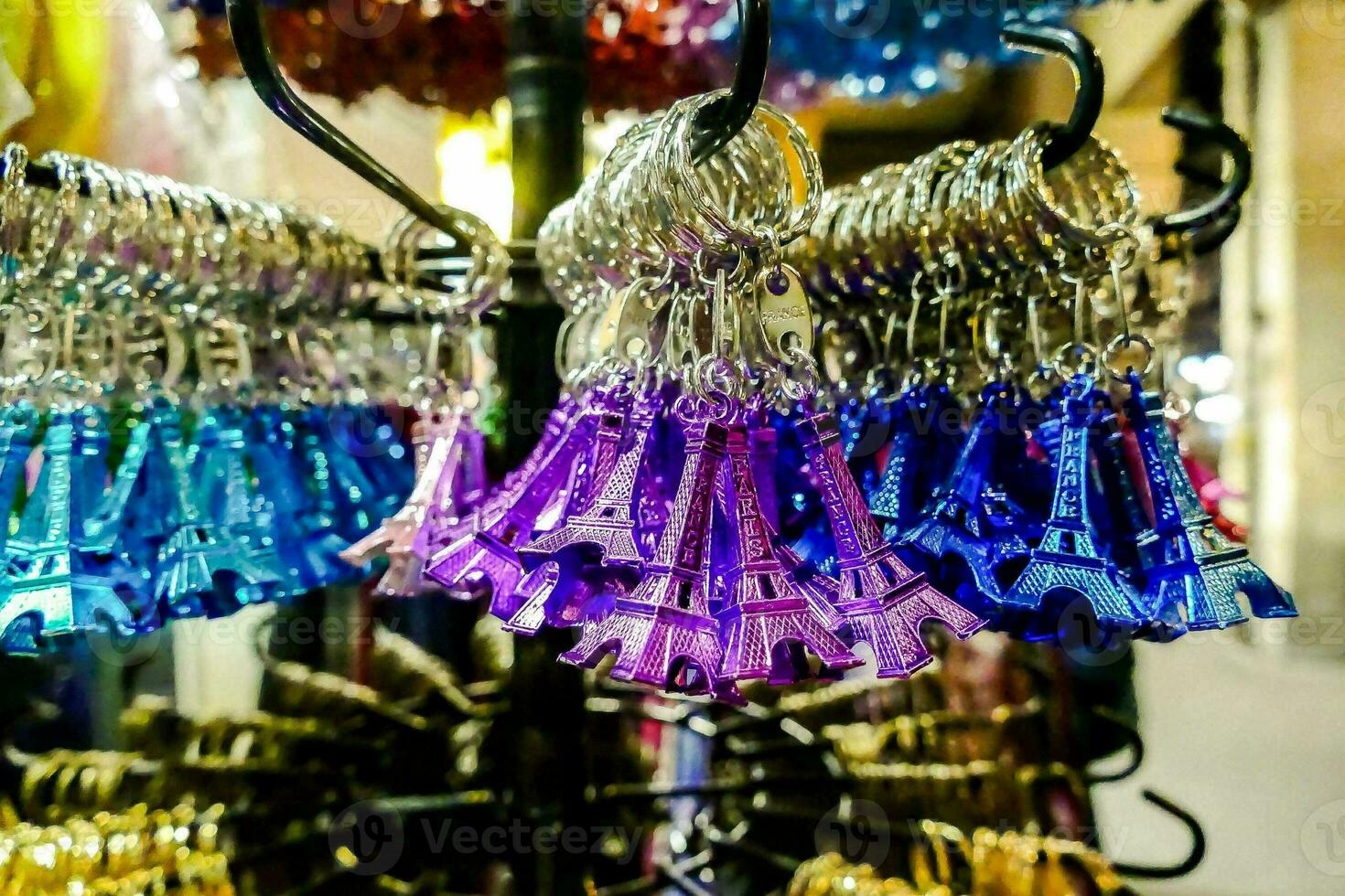 colorful eiffel tower key chains hanging on a rack in a store photo