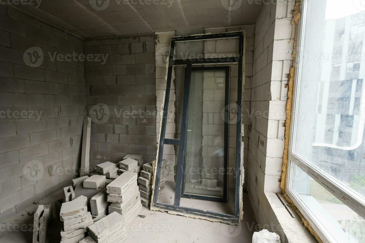 Break the wall for renovation and build the door for entrance of building. Wheelbarrow with broken bricks in site construction. photo