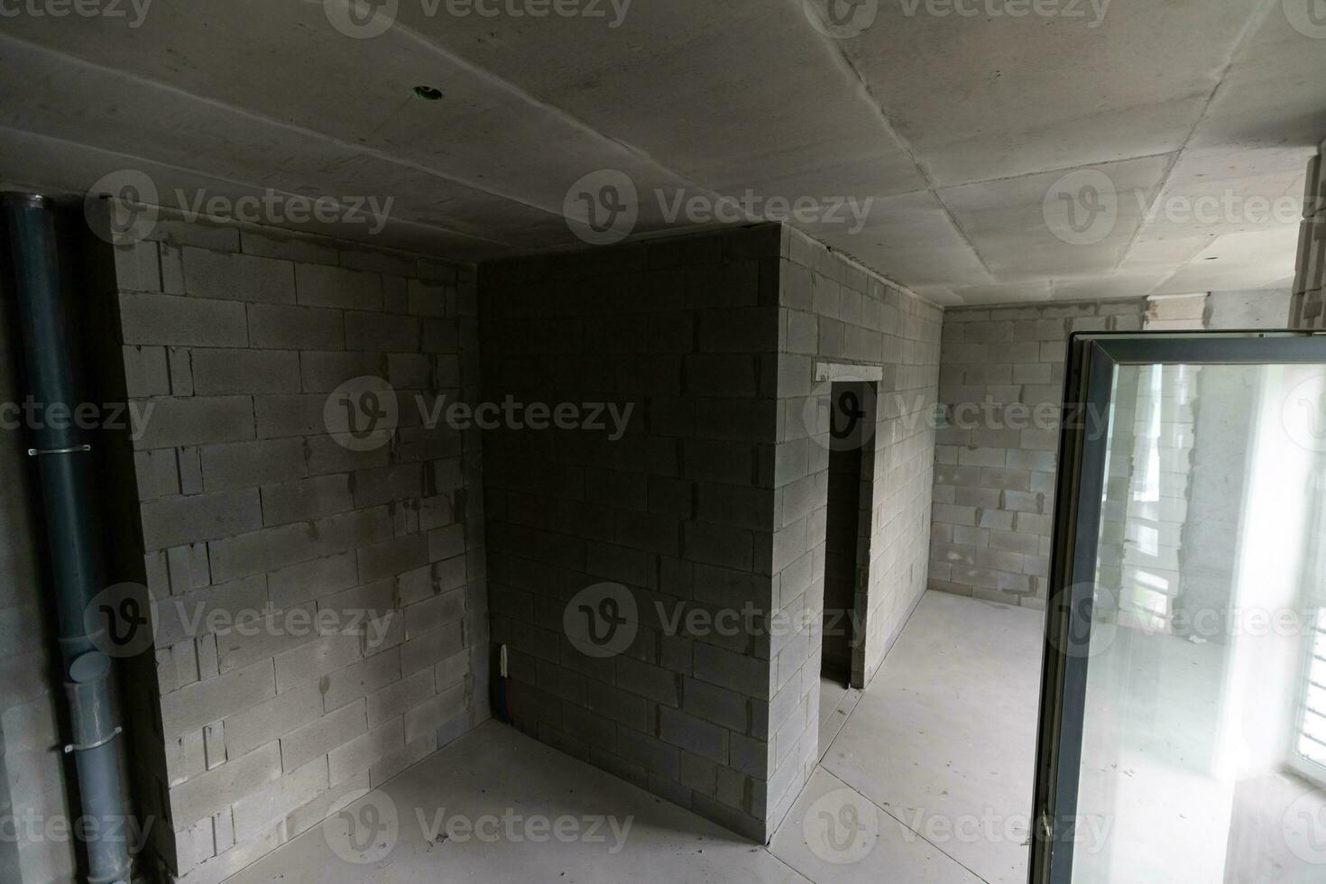 Small apartment without repair in a new building. A room in an unfinished house. Walls of foam block and concrete floor in a tiny apartment. photo