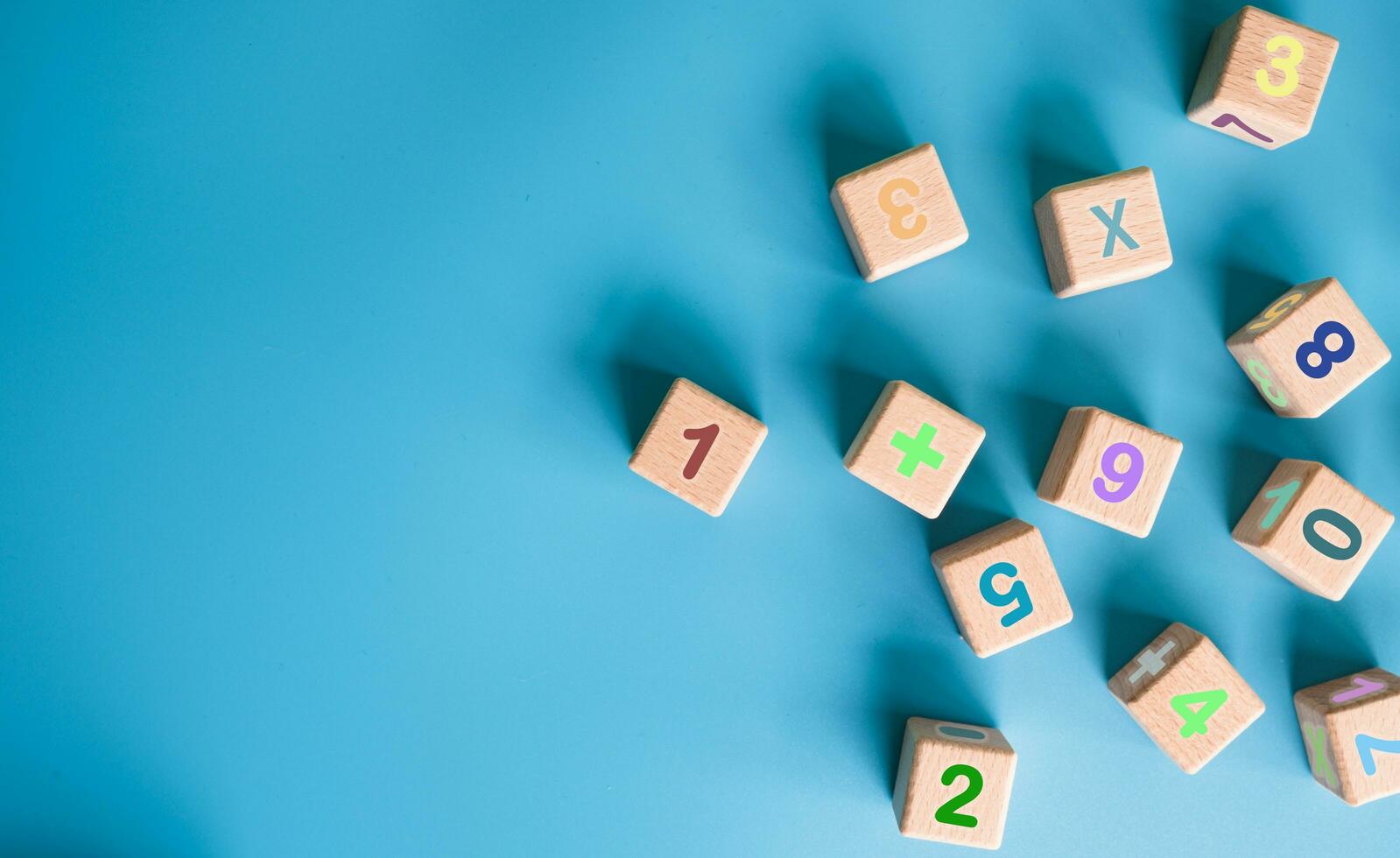 Colorful wooden cubes with numbers scattered on blue background. learning, increasing IQ, development for children. Top view of children's toys. Educational games. photo