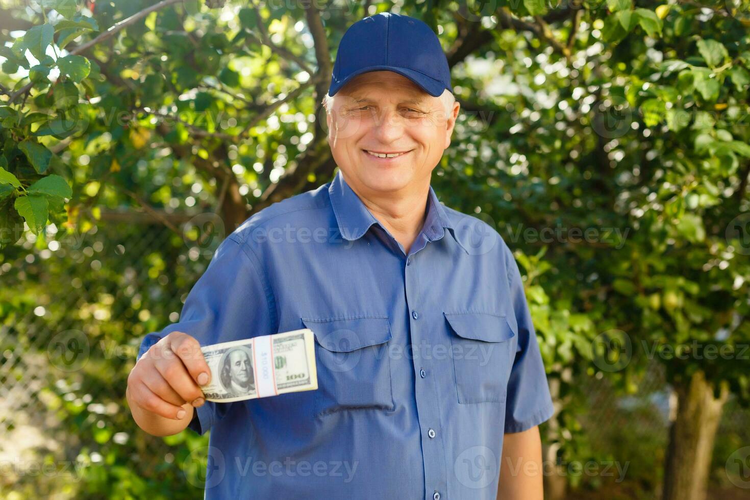 An elderly man holding a stack of money photo