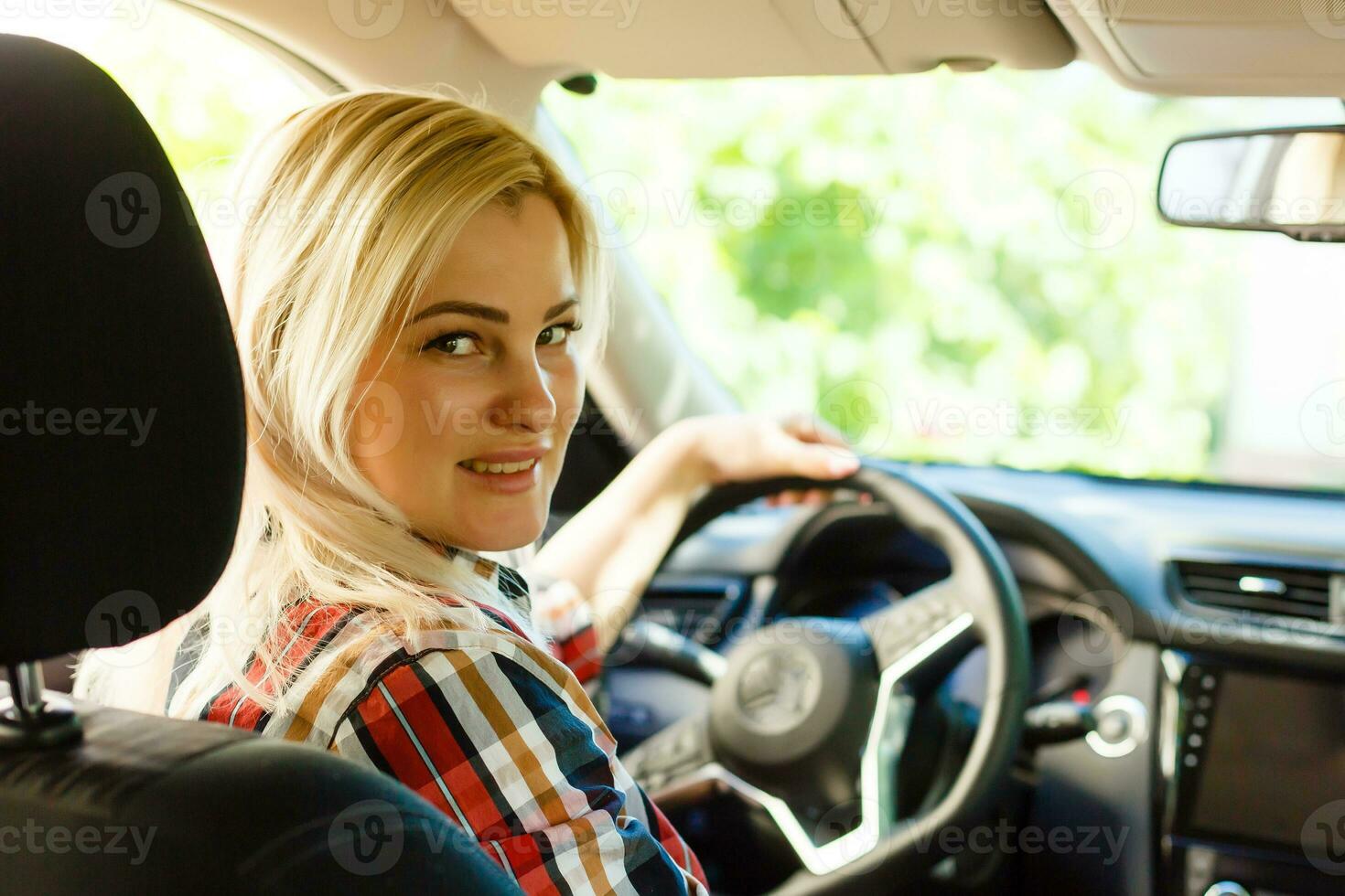 sonriente mujer sentado en coche foto