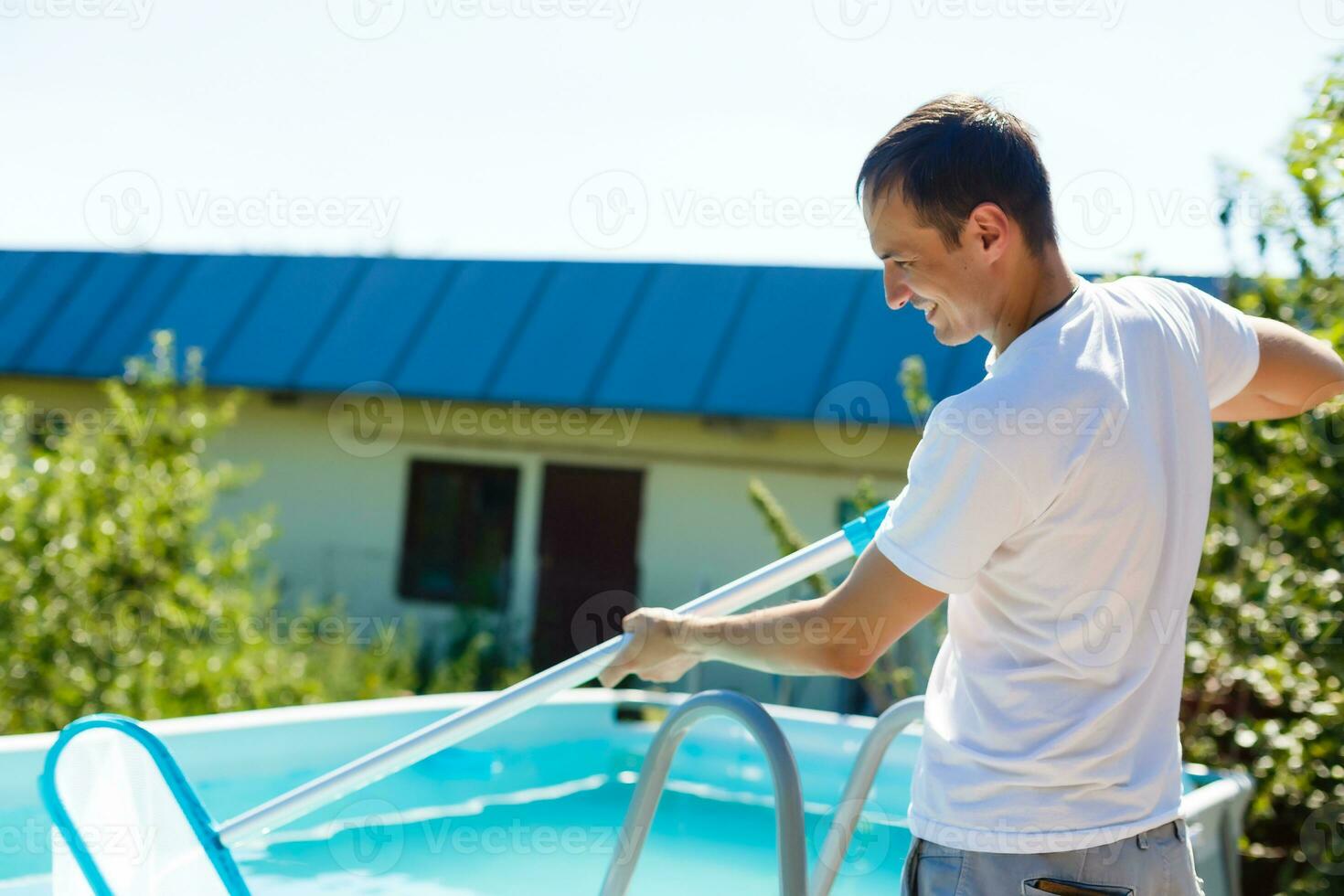 hombre limpieza el piscina a su país casa. verano a hogar concepto. estilo de vida foto